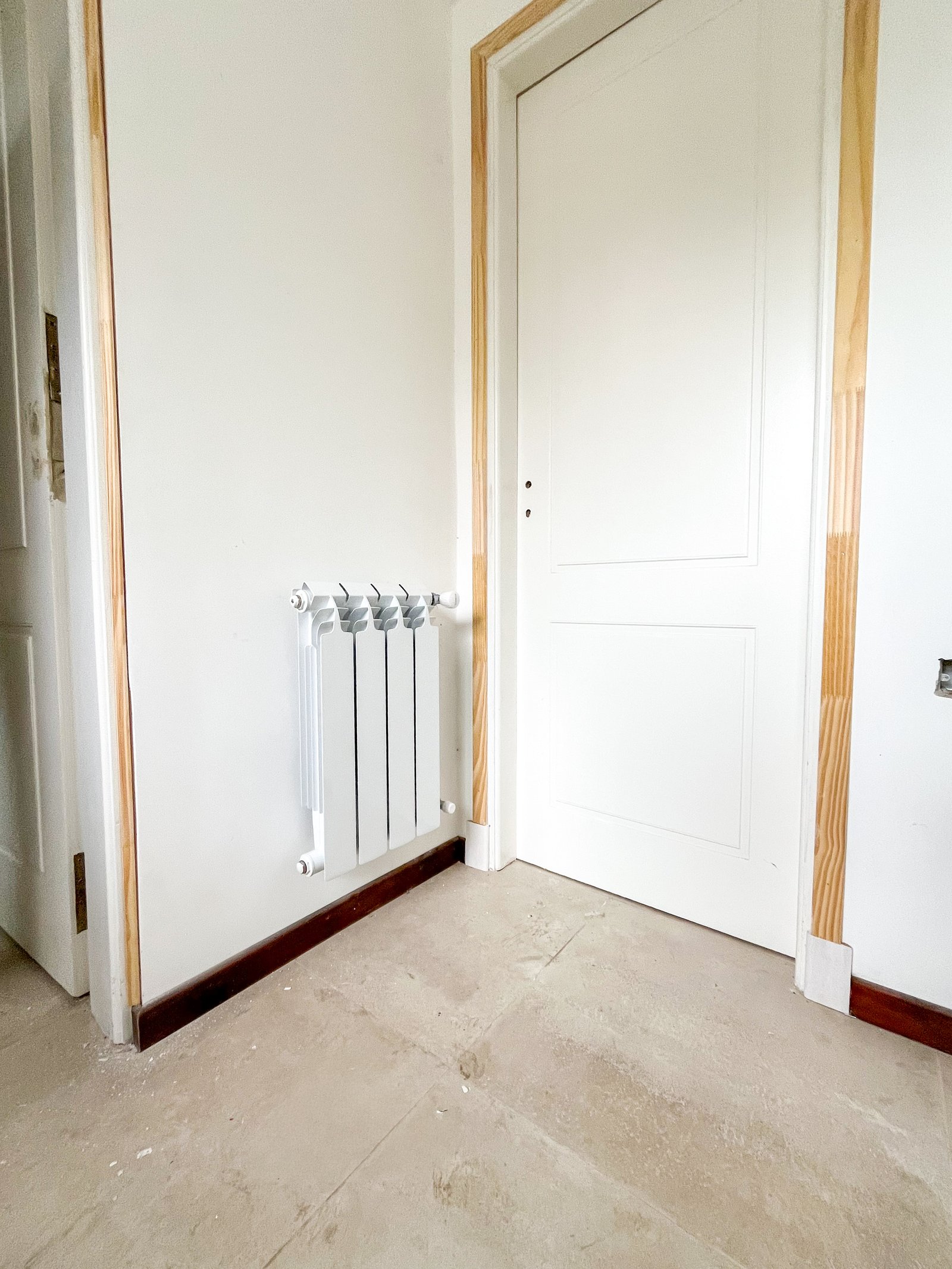 radiador blanco junto a puerta blanca y piso de piedra — proyecto Instalación de Radiadores en Tigre, por Climatizacion HD, en B1648 Tigre