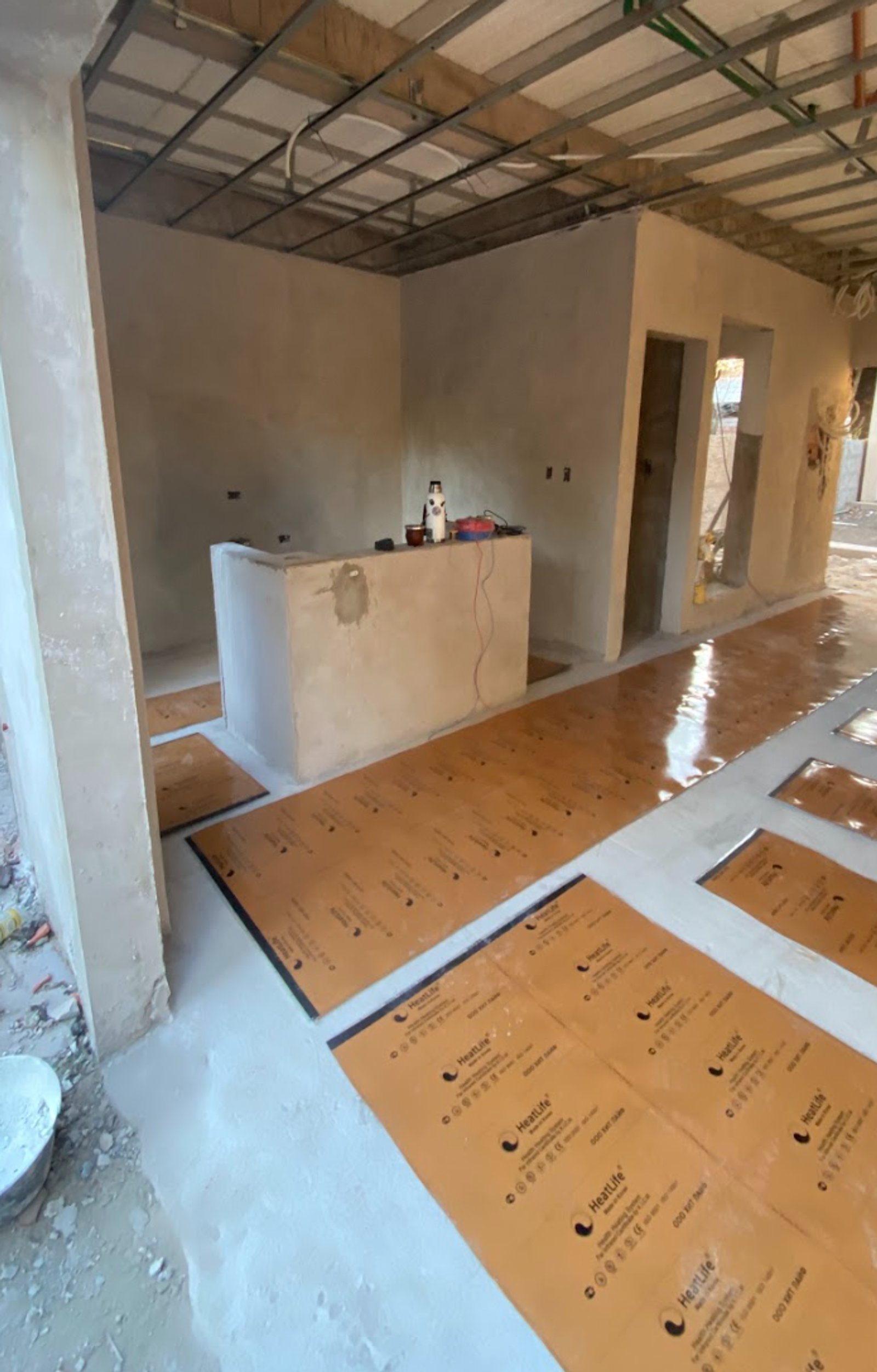 interior en construccion con proteccion de piso — proyecto Berazategui, por HEAT LIFE, en Berazategui