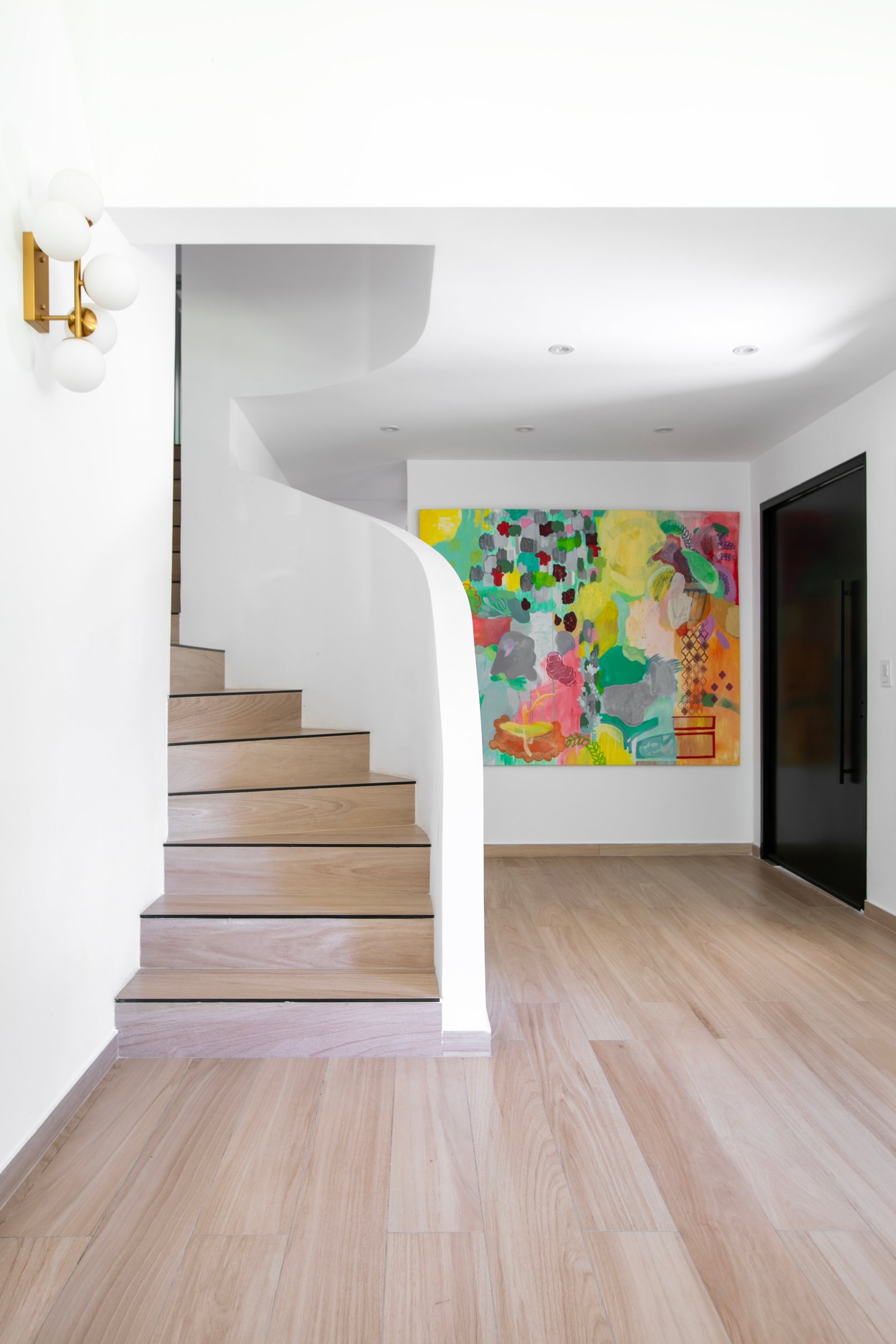 Escalera flotante curva moderna con arte abstracto y luz minimalista — proyecto PROYECTO CAT COURREGES, por ILVA, en Provincia de Buenos Aires