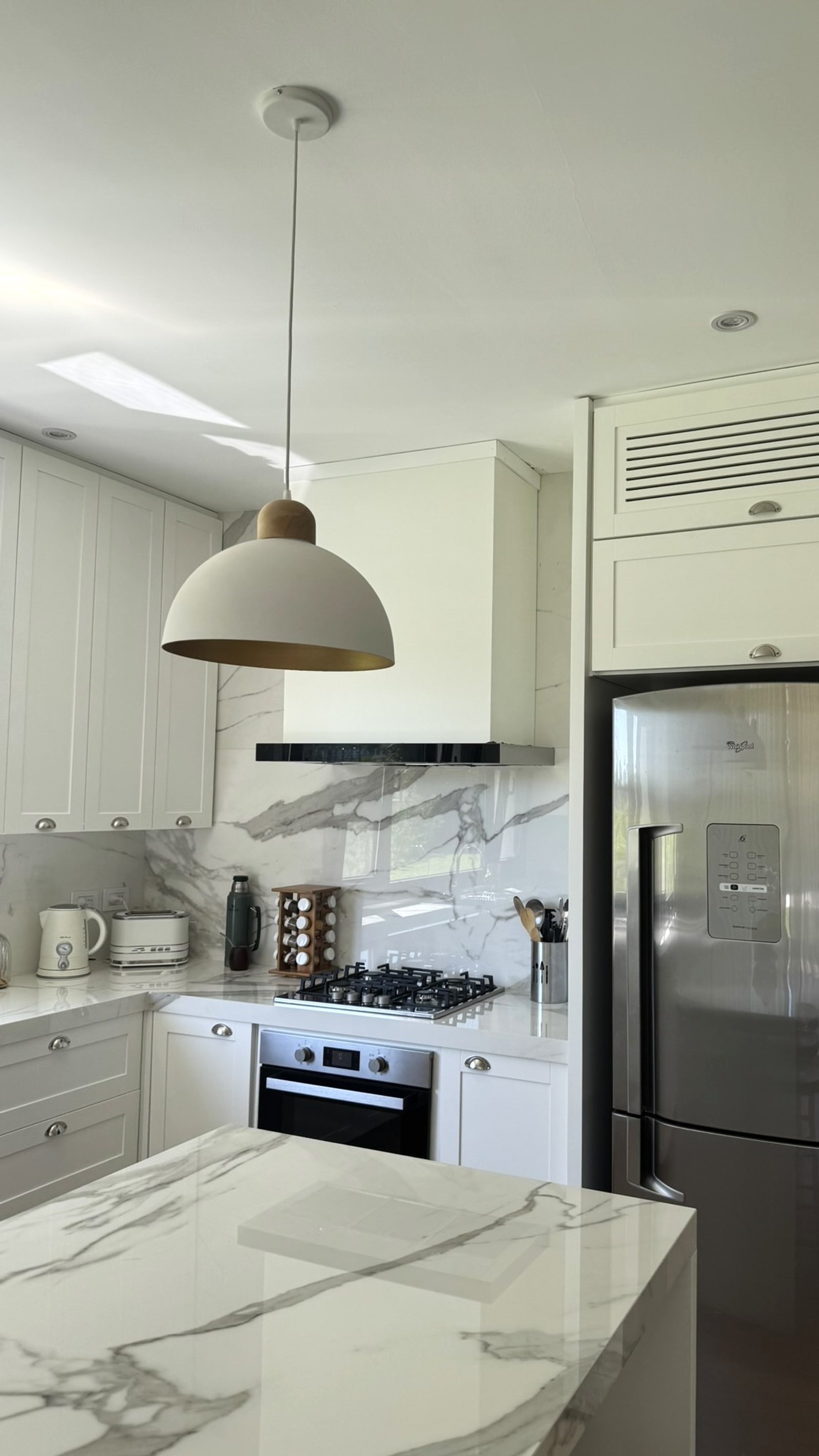 Cozinha moderna escandinava com ilha, mármore e eletrodomésticos embutidos — projeto Casa MC, por Hermann Arquitectos, em Bv. Central