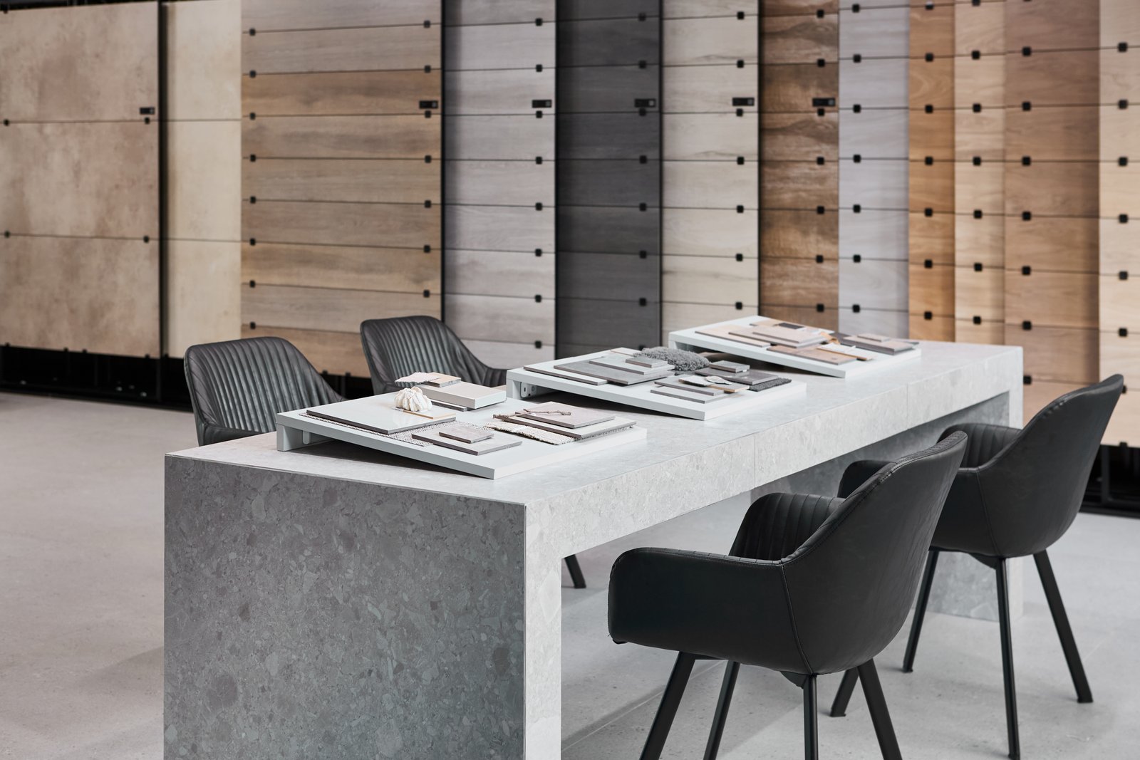 local comercial con mesa de piedra y sillas negras — proyecto Showroom, por San Lorenzo Design, en Buenos Aires