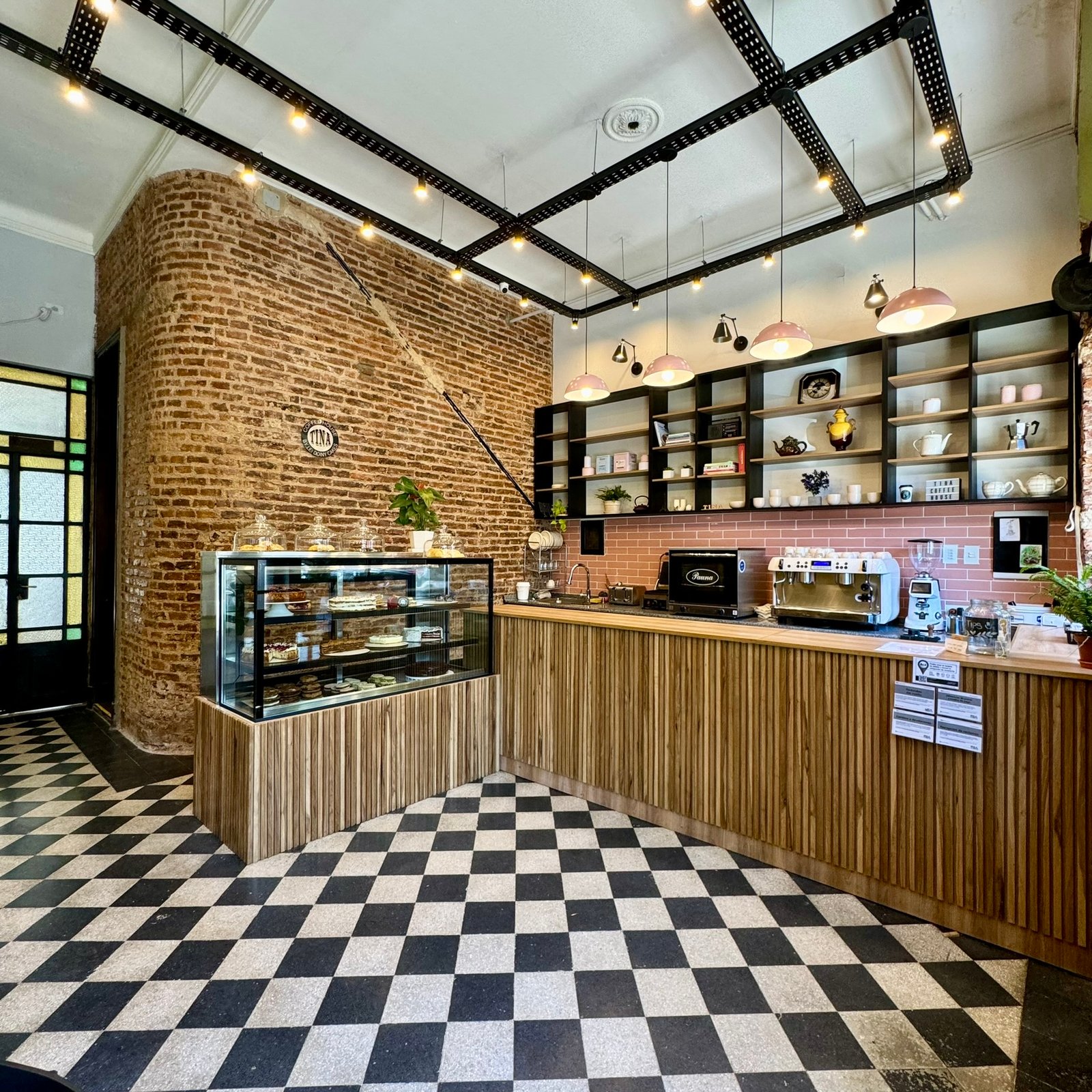 Cafeteria com tijolo aparente e piso xadrez — projeto UGA Coffee House, por MDBK Arquitectura, em Almagro