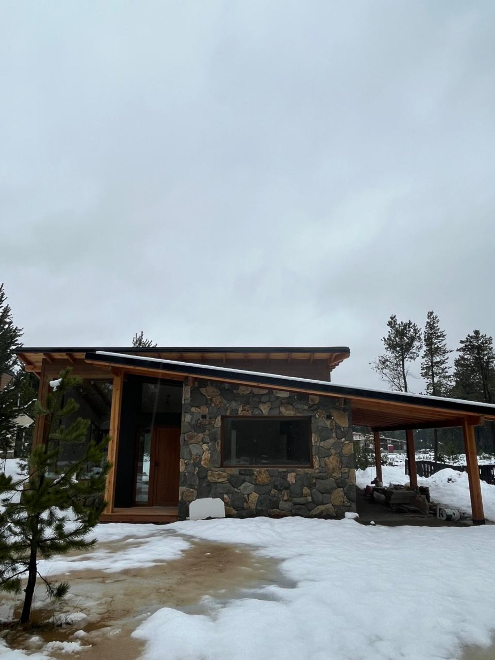 cabaña moderna rústica con fachada de piedra y nieve — proyecto Casa Arcoiris, por Arquitecta Grace Overgaard, en Acceso Al Challhuaco