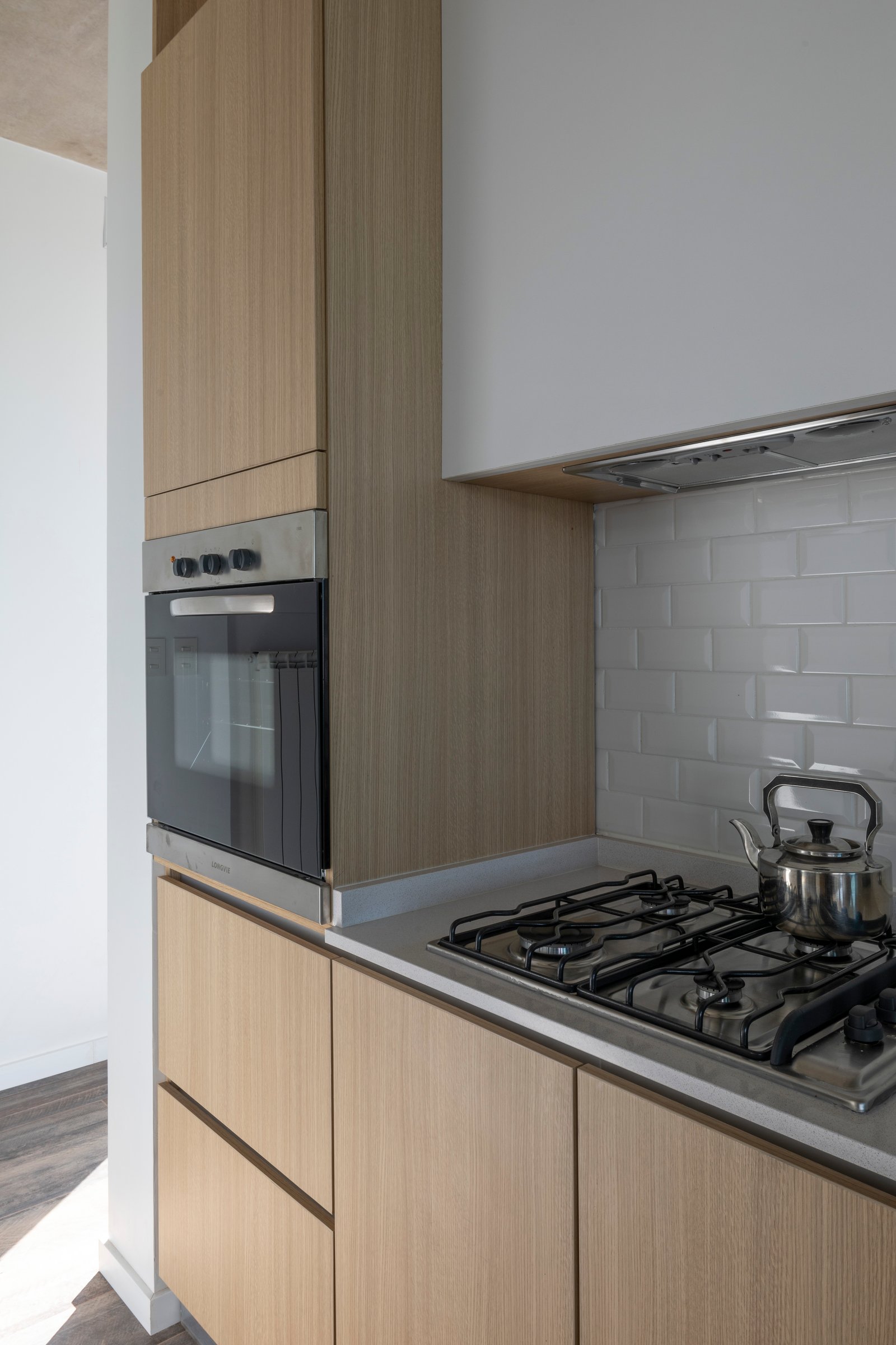 Cocina moderna con muebles de madera natural y electrodomésticos integrados — proyecto Casa Cruz , por Grupo CRBN, en B2812 Exaltación de la Cruz