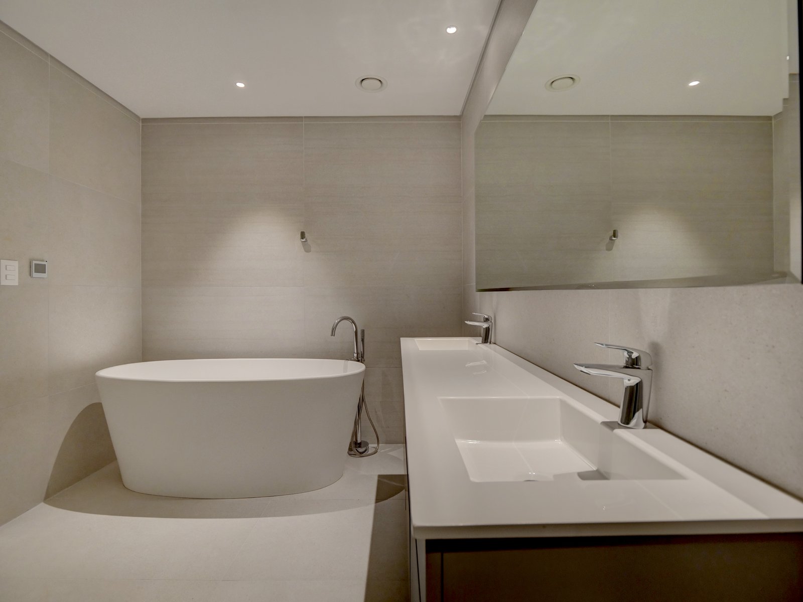Baño moderno minimalista con bañera exenta y lavabo integrado — proyecto LE PARQ TORRE IV , por ILVA, en Provincia de Buenos Aires
