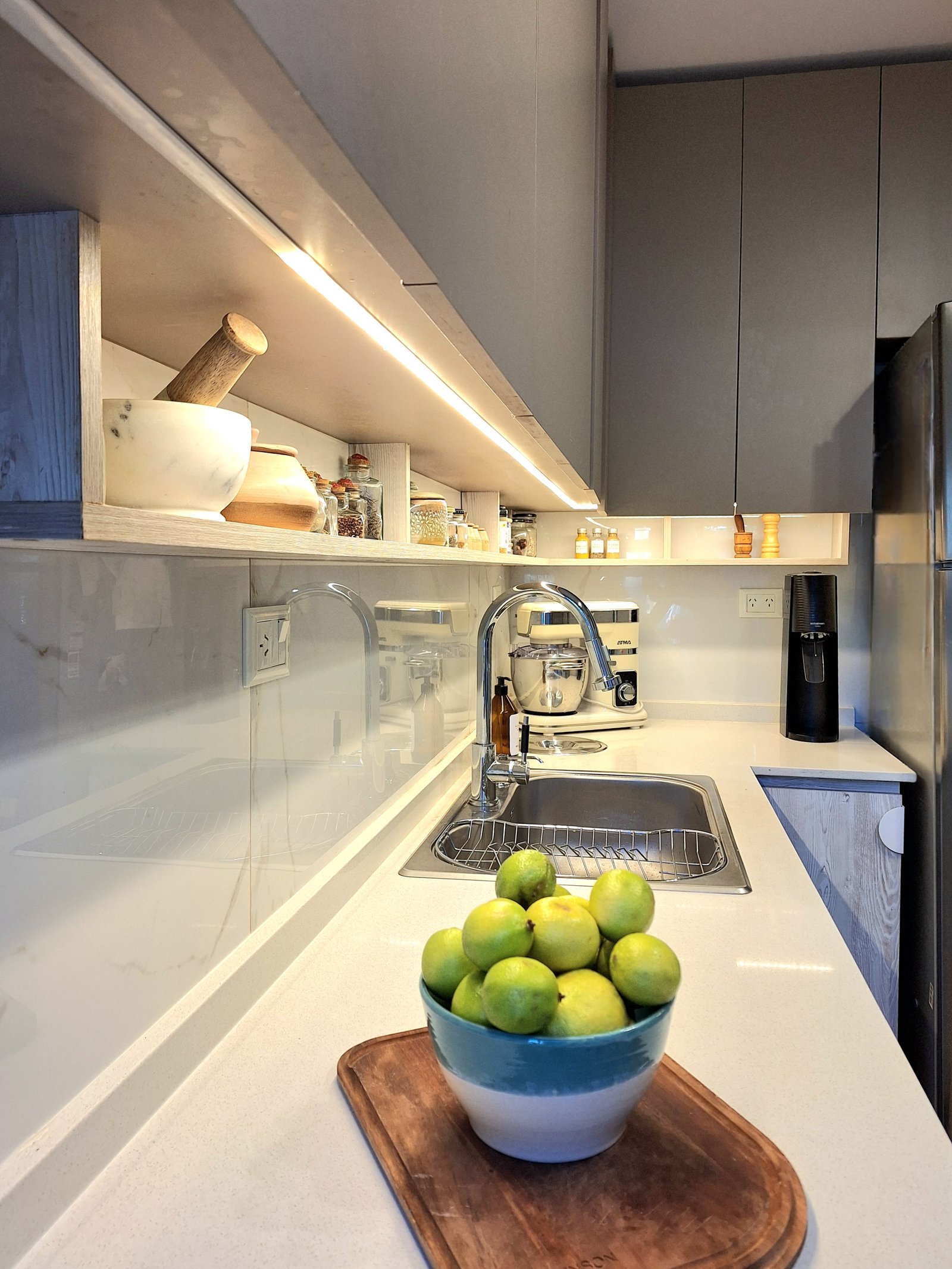 Cocina moderna con iluminación integrada y gabinetes grises — proyecto PROYECTO PORTEZUELO, por HALESA ESTUDIO, en Av. de los Lagos 6595