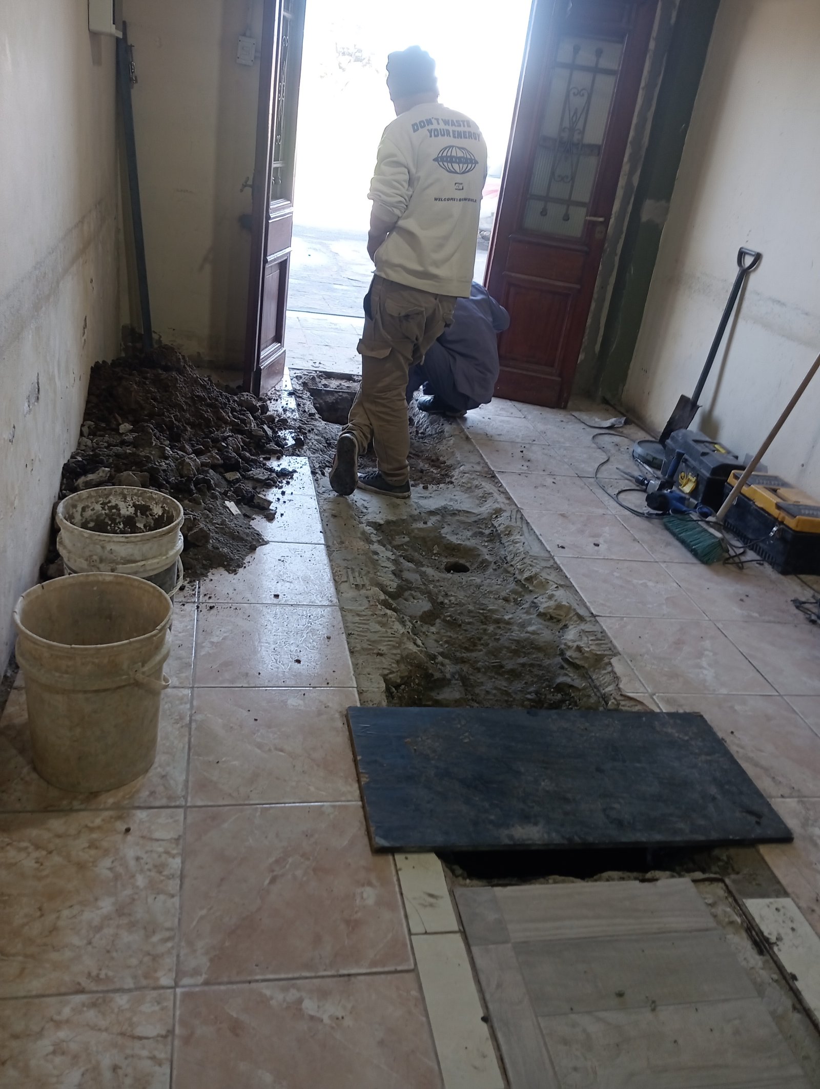 obra en interior, vereda con tierra y herramientas — proyecto Cloaca en la iglesia , por A&E construcciónes, en Francisco Alvarez