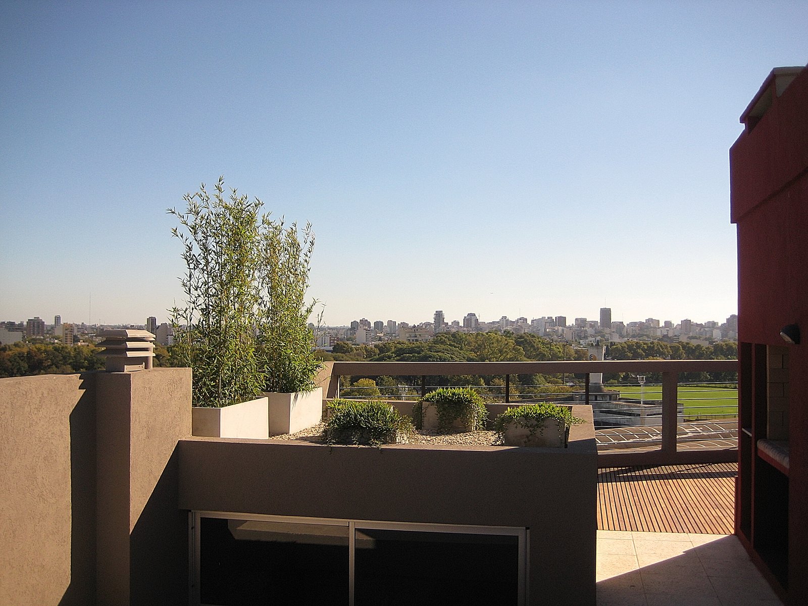 Terraza moderna en edificio alto con vista urbana y vegetación — proyecto Edificio San Martin, por LW Lopez Wolder arquitectos, en Av. S. Martín 5063