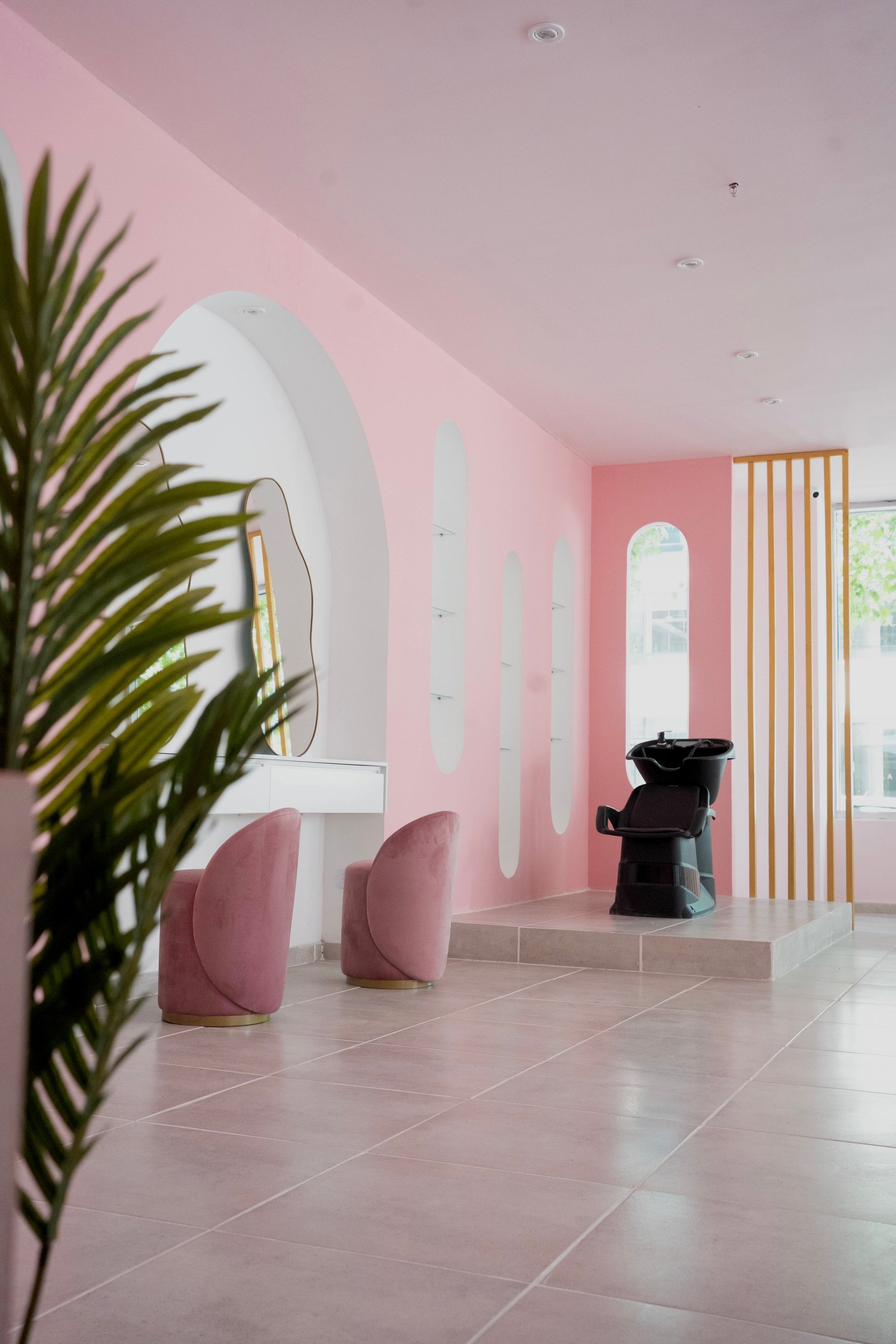 Salão de cabeleireiro rosa com cadeiras curvas e espelho abstrato — projeto Churri Beauty, por vil arquitectura y diseño, em Olga Cossettini 300