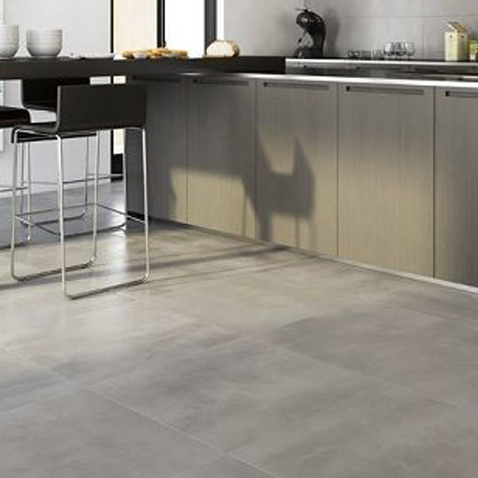 cocina moderna con isla, taburetes industriales y suelo de cerámica gris — proyecto Porcelanatos, por The Flooring Company