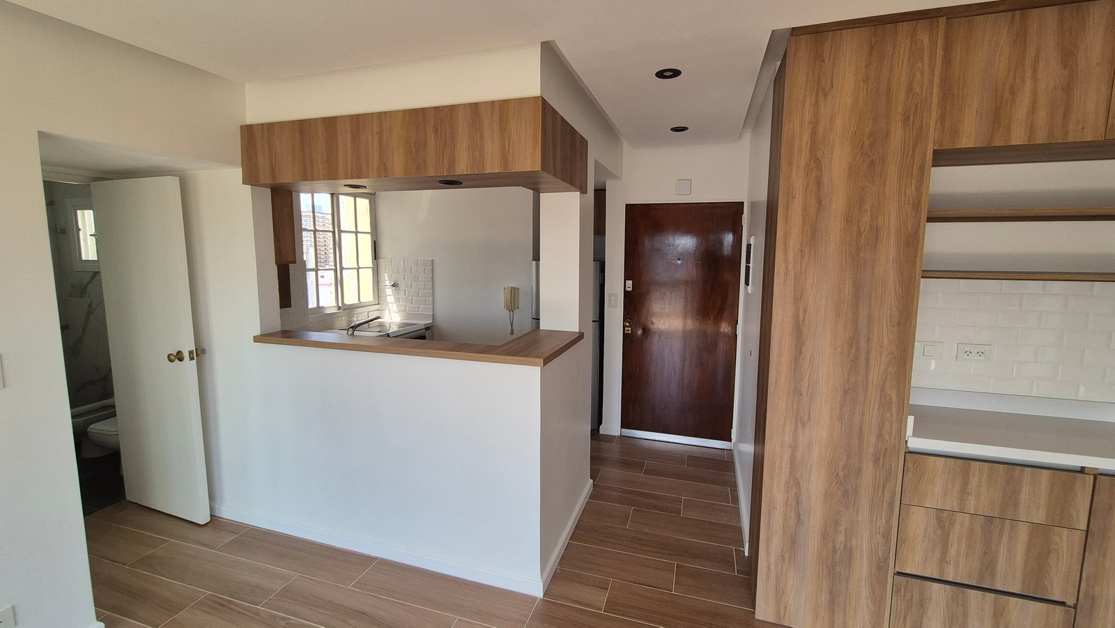 Cocina moderna abierta con muebles de madera y blanco — proyecto Living - Remodelación Soho, por RenovArqui, en Palermo