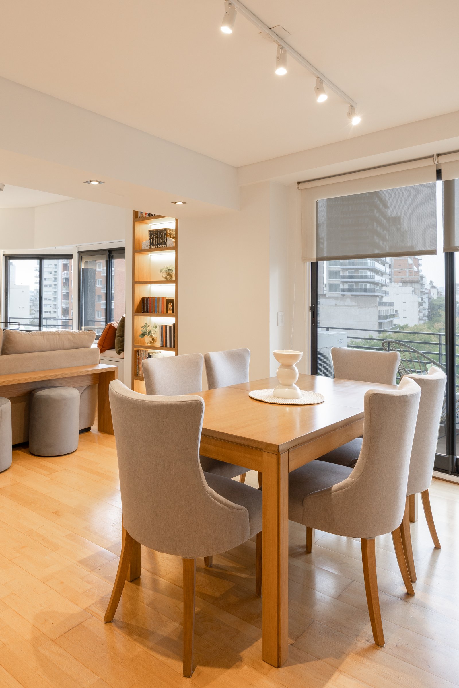 Comedor moderno integrado con living, mucha luz natural y estanterías — proyecto Rio, por Martina Kleinert, en Saavedra