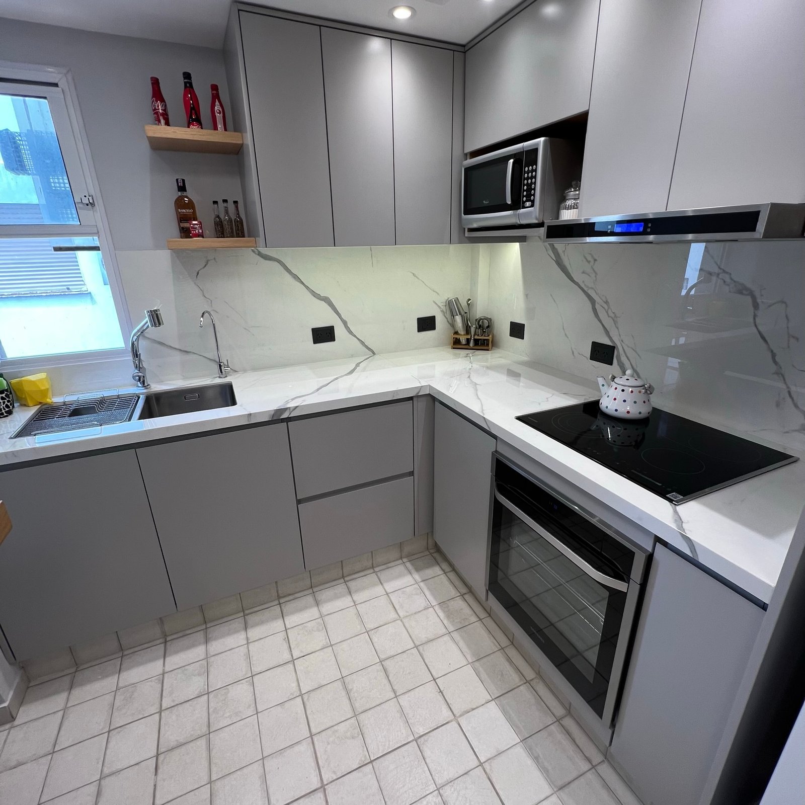 Cocina moderna gris minimalista con mesadas de mármol y electrodomésticos integrados — proyecto Diaz Velez I, por MDBK Arquitectura, en Almagro