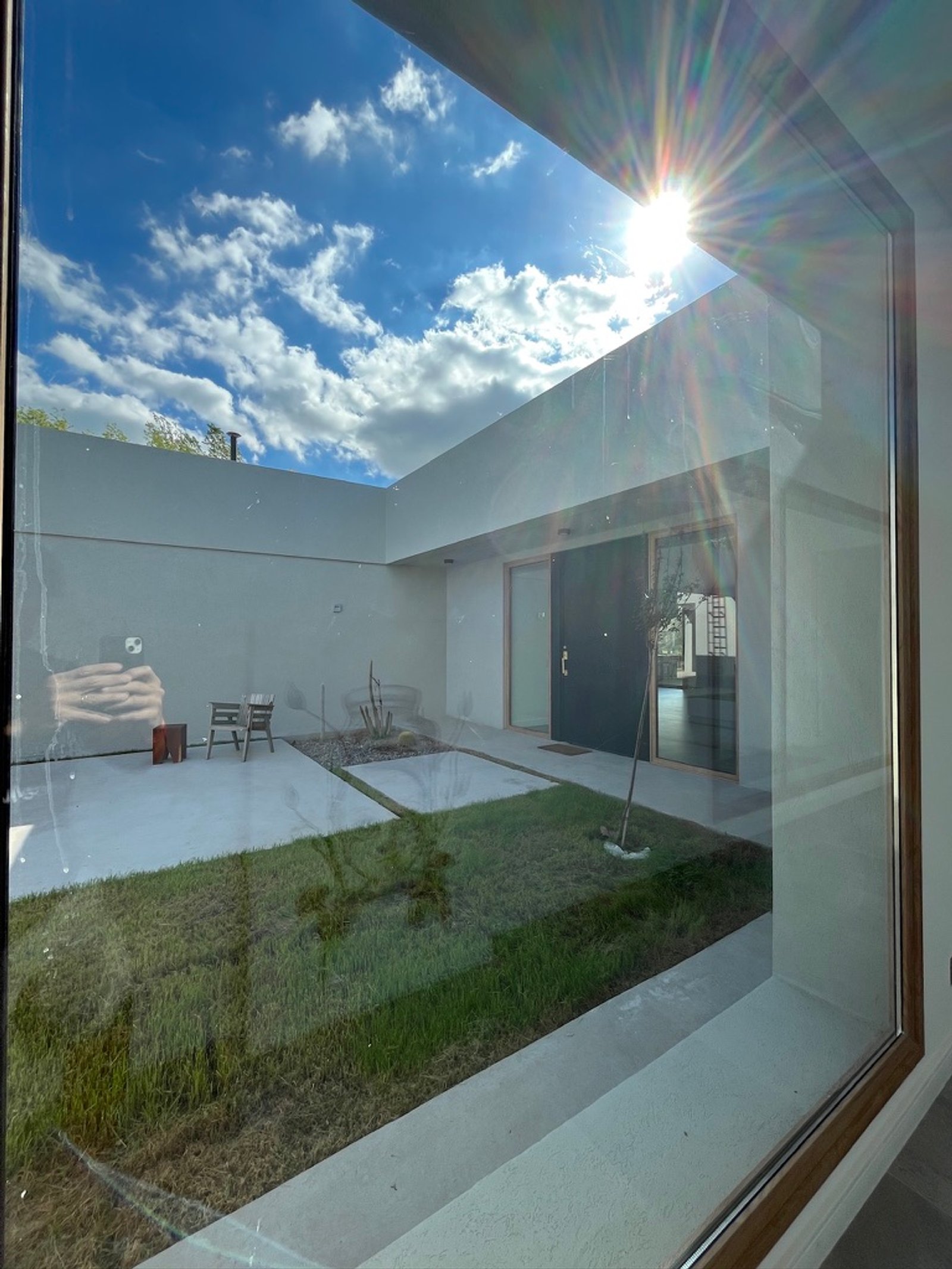 Casa moderna com pátio e céu nublado — projeto La Colina, por Arcucci Arquitectura, em La Colina Villa de Campo