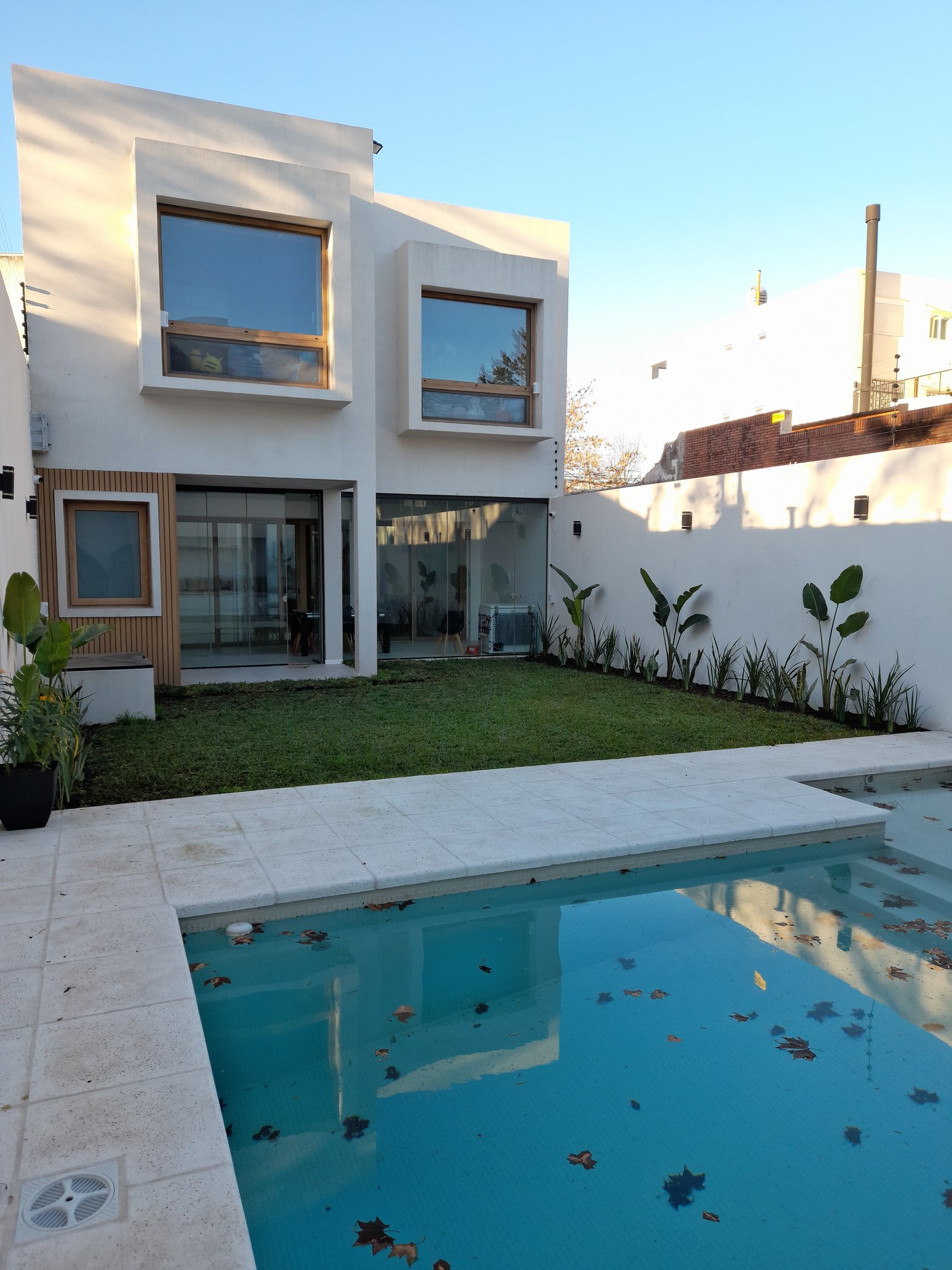 Casa moderna con piscina y jardín, arquitectura geométrica — proyecto Proy. integral - Villa Devoto, por Jardinmania, en Cdad. Autónoma de Buenos Aires