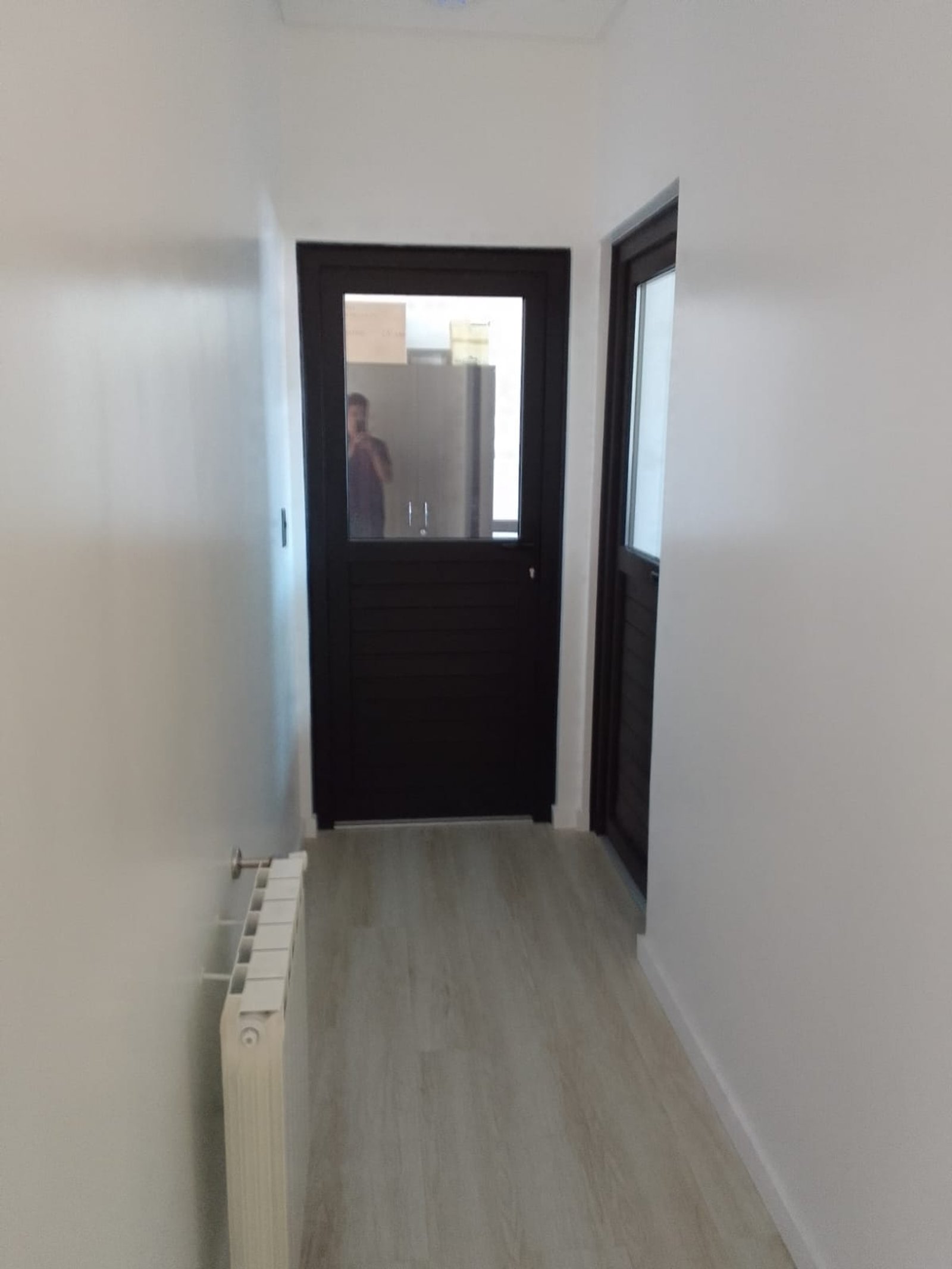 Corredor moderno com porta envidraçada e radiador — projeto Drogueria en Avellaneda, por Arquitecto Guido Niccoli, em B1872 Sarandí