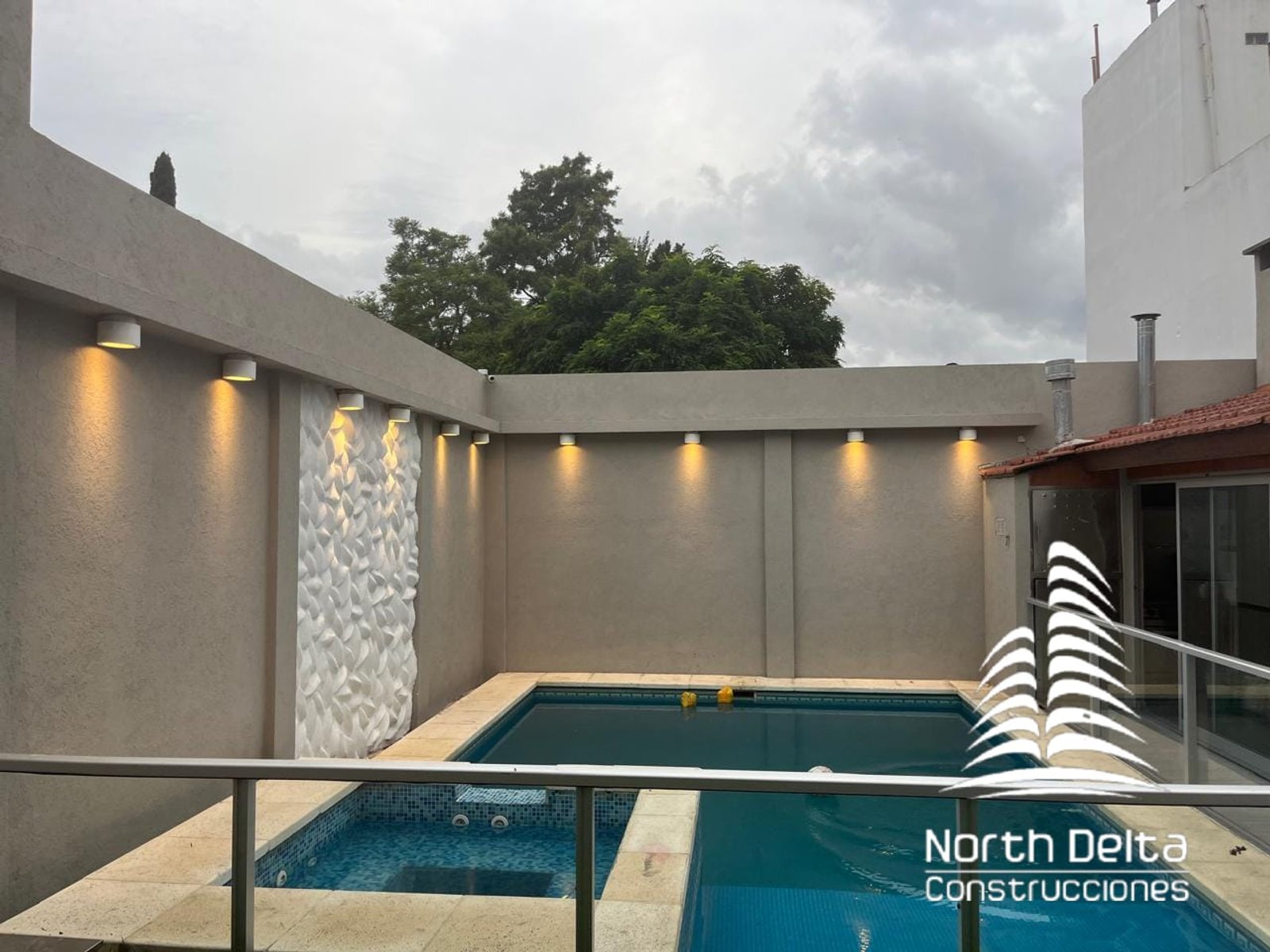 piscina moderna exterior con pared texturizada — proyecto Construcción de Piscina+ Jacuzzi, por North Delta Construcciones, en El Palomar