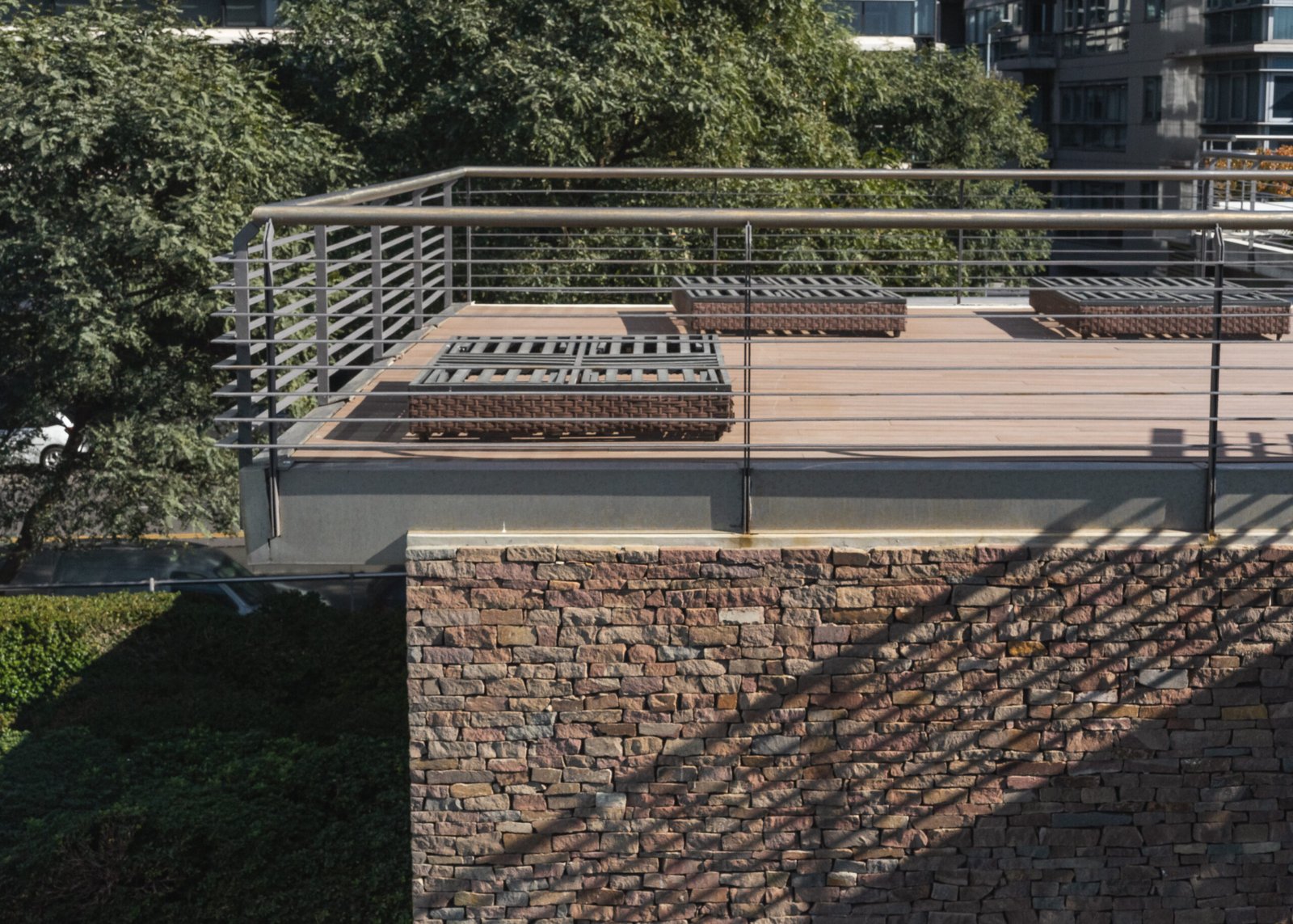 Terraza moderna con deck de madera y muro de piedra — proyecto Outdoor, por The Flooring Company