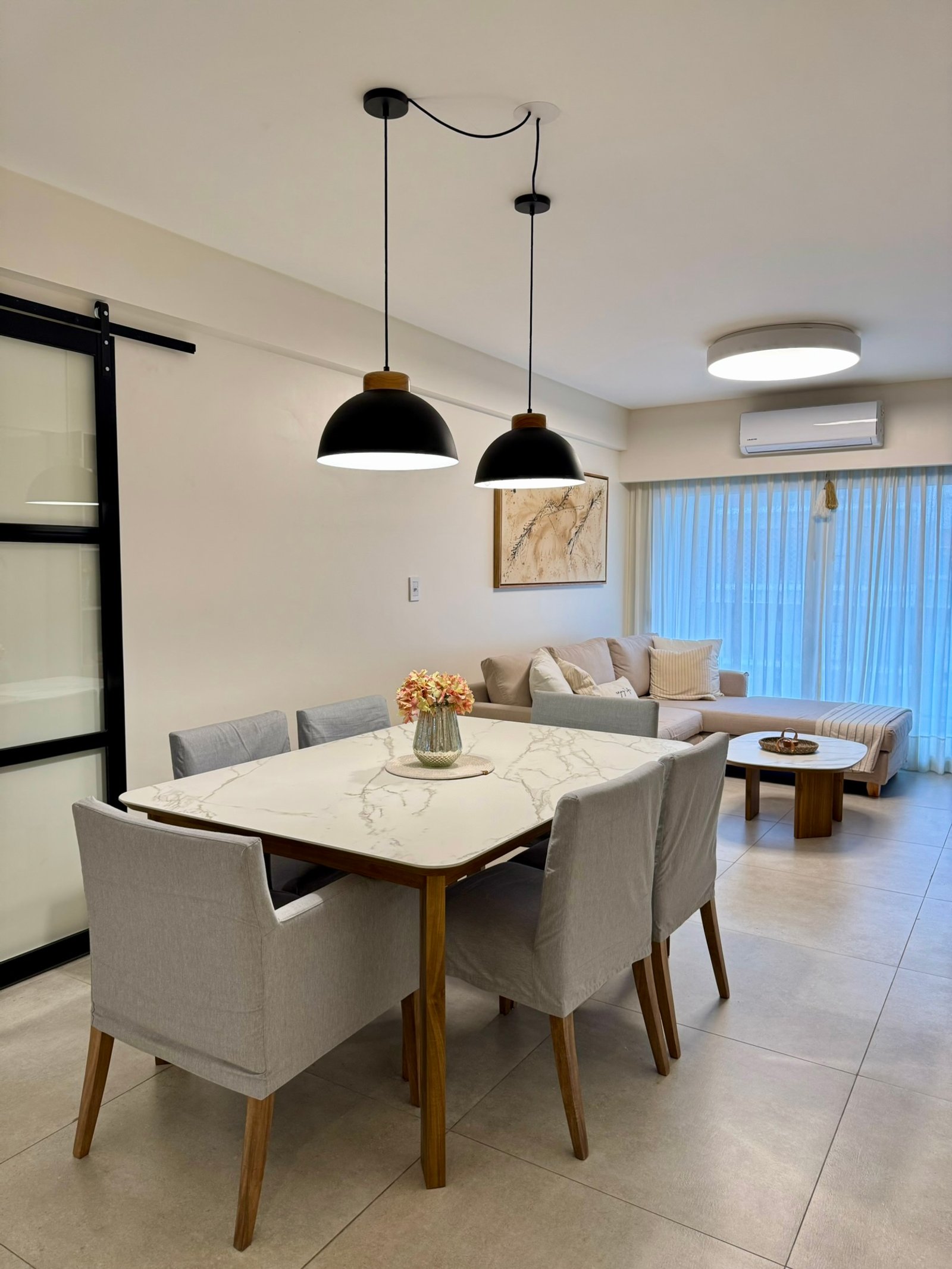 Comedor moderno integrado a living, mesa mármol, luces colgantes — proyecto Corrientes I, por MDBK Arquitectura, en Villa Crespo