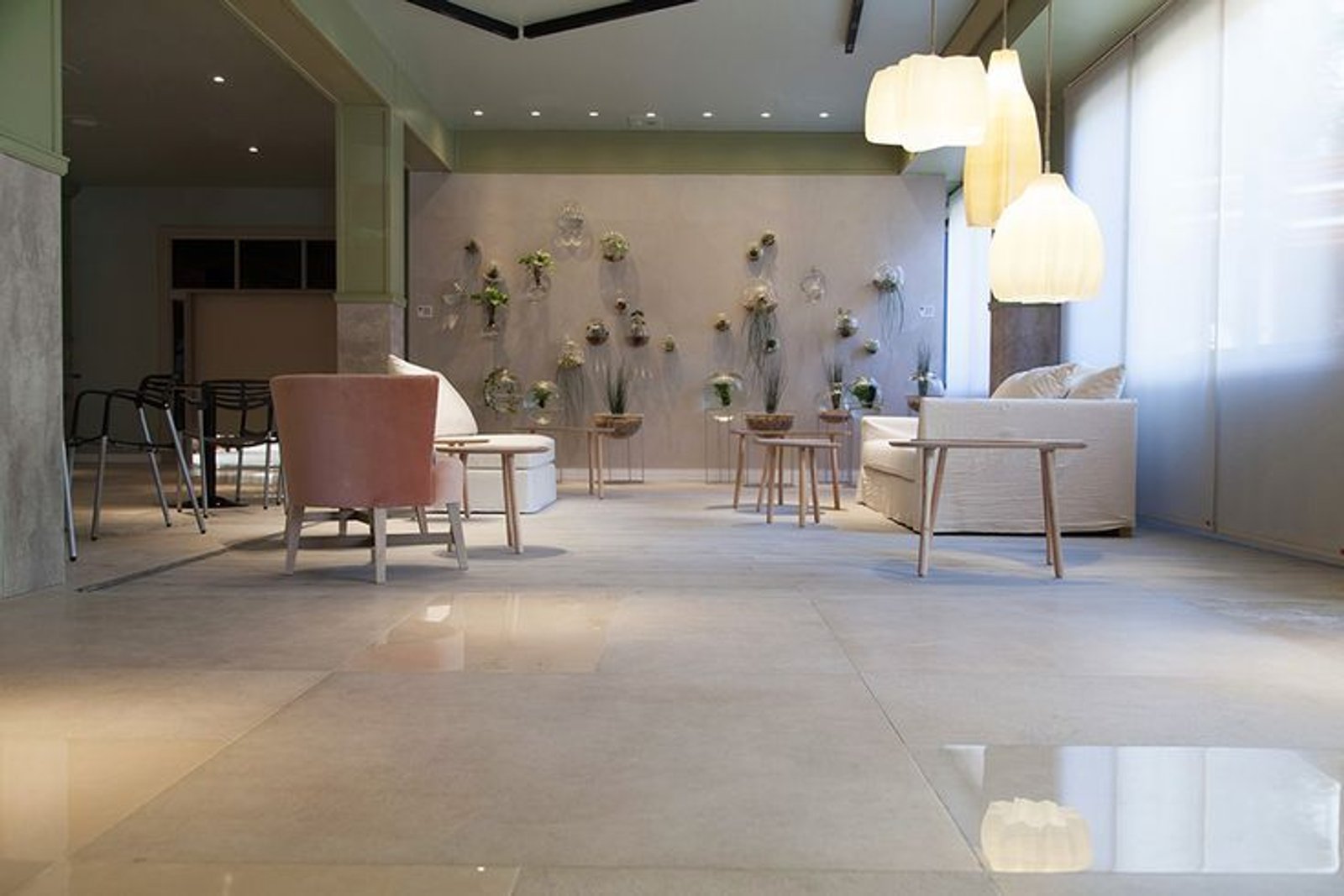 Sala de espera moderna com poltrona curva bordô e pendentes grandes — projeto Casa Foa Distrito Elcano 2021, por Vite Porcellanato, em Buenos Aires