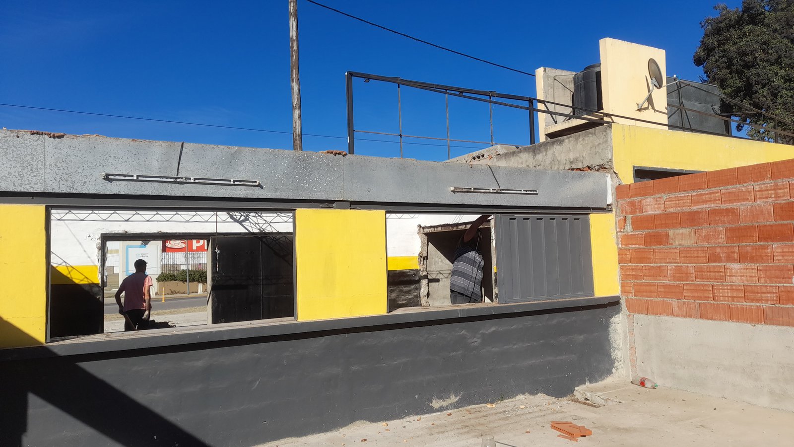 Fachada comercial en construcción con persianas metálicas — proyecto Remodelación Bodegón del depo, por CN Construcciones, en Alta Gracia