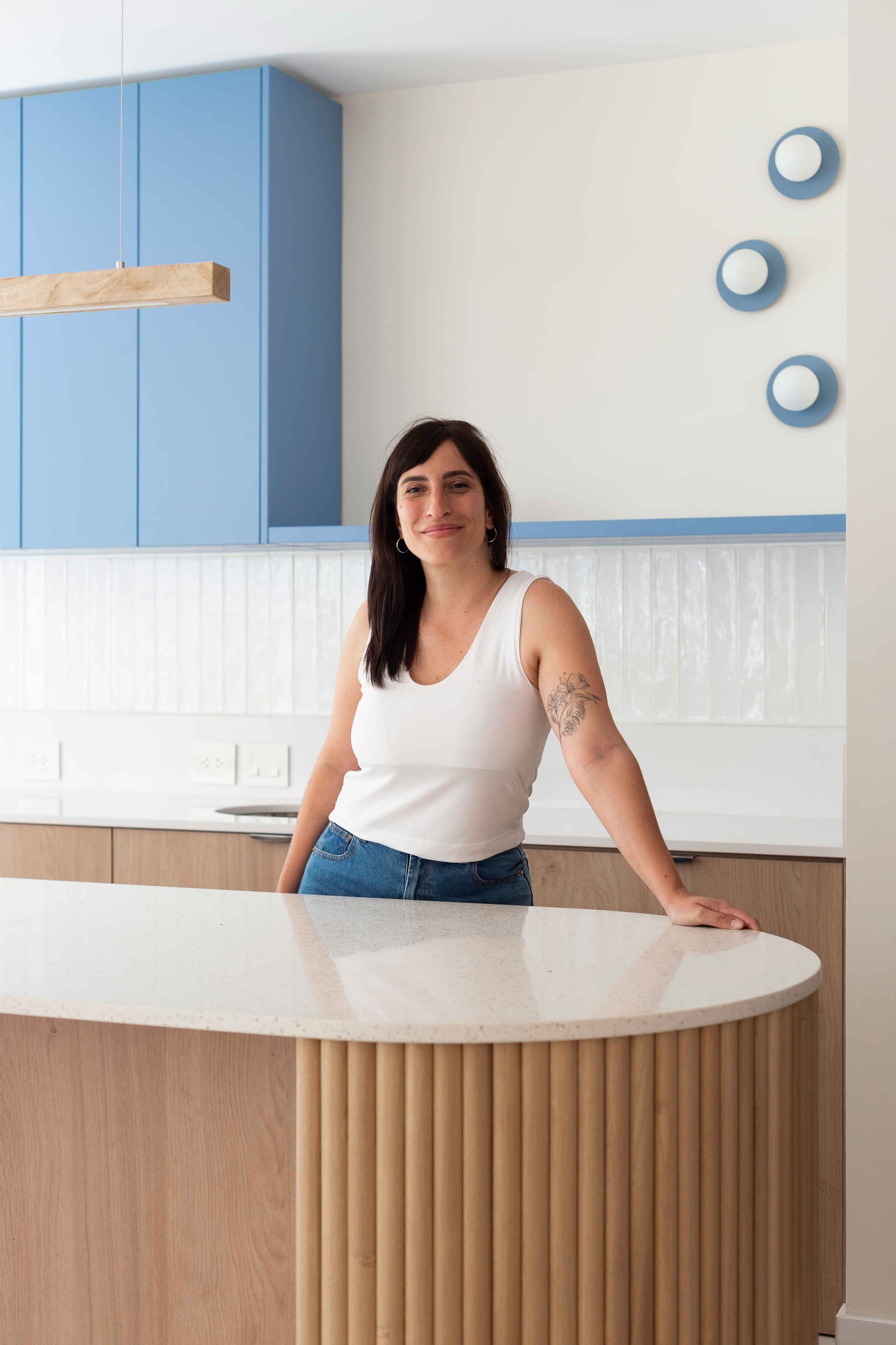 Cozinha moderna com ilha curva e armários azuis claros — projeto Grecia, por Bouré Studio, em Núñez