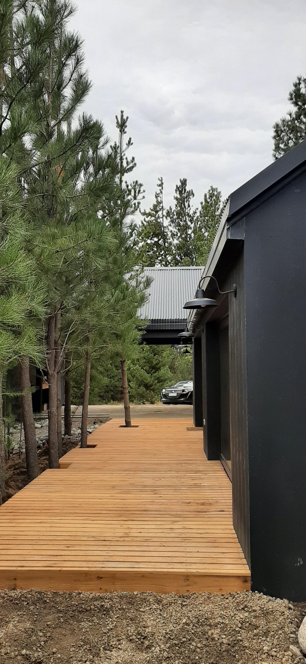Fachada moderna com deck de madeira e ambiente de floresta — projeto Casa LA MOROCHA, por Showhouse Bariloche, em San Carlos de Bariloche