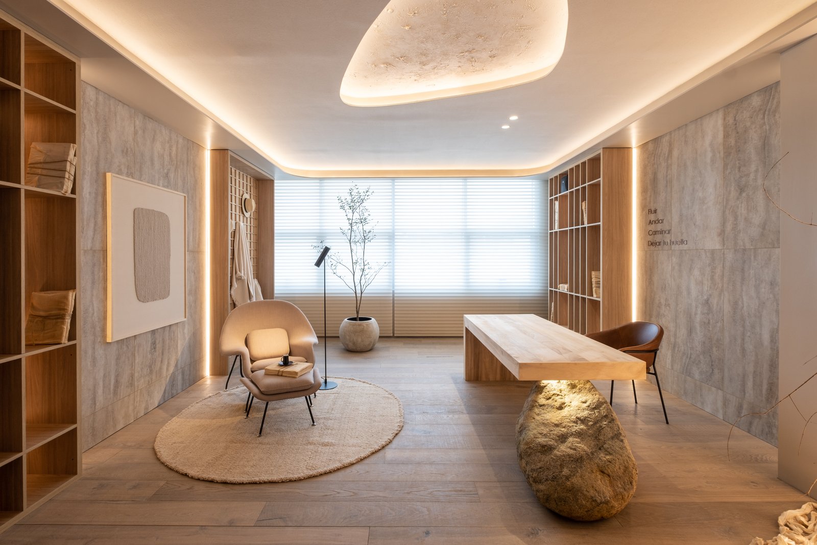 Oficina moderna con madera natural, iluminación indirecta y sillón curvo — proyecto Marmoles, por Vite Porcellanato