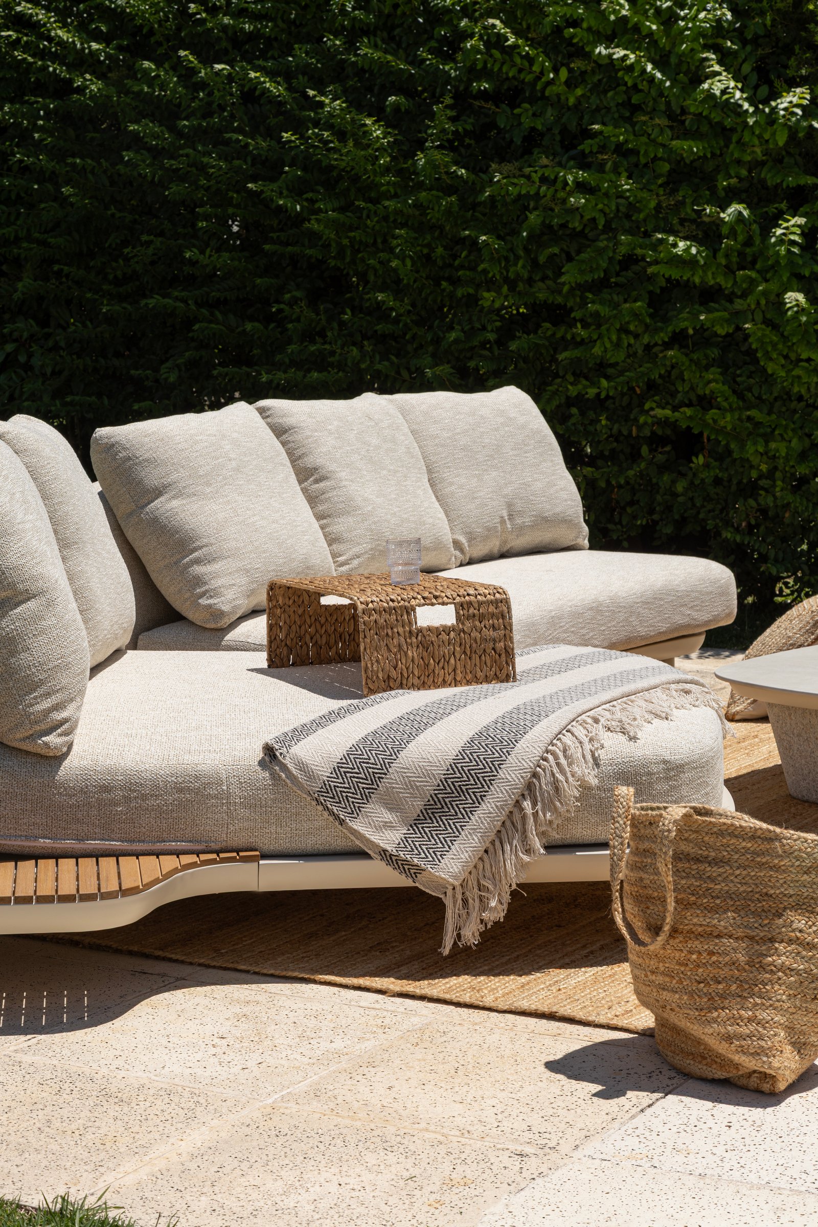 Sofá exterior modular beige con mesa de mimbre y manta a rayas — proyecto Nuevos diseños de Muebles de Exterior , por DESDE ASIA, en Malabia 1359