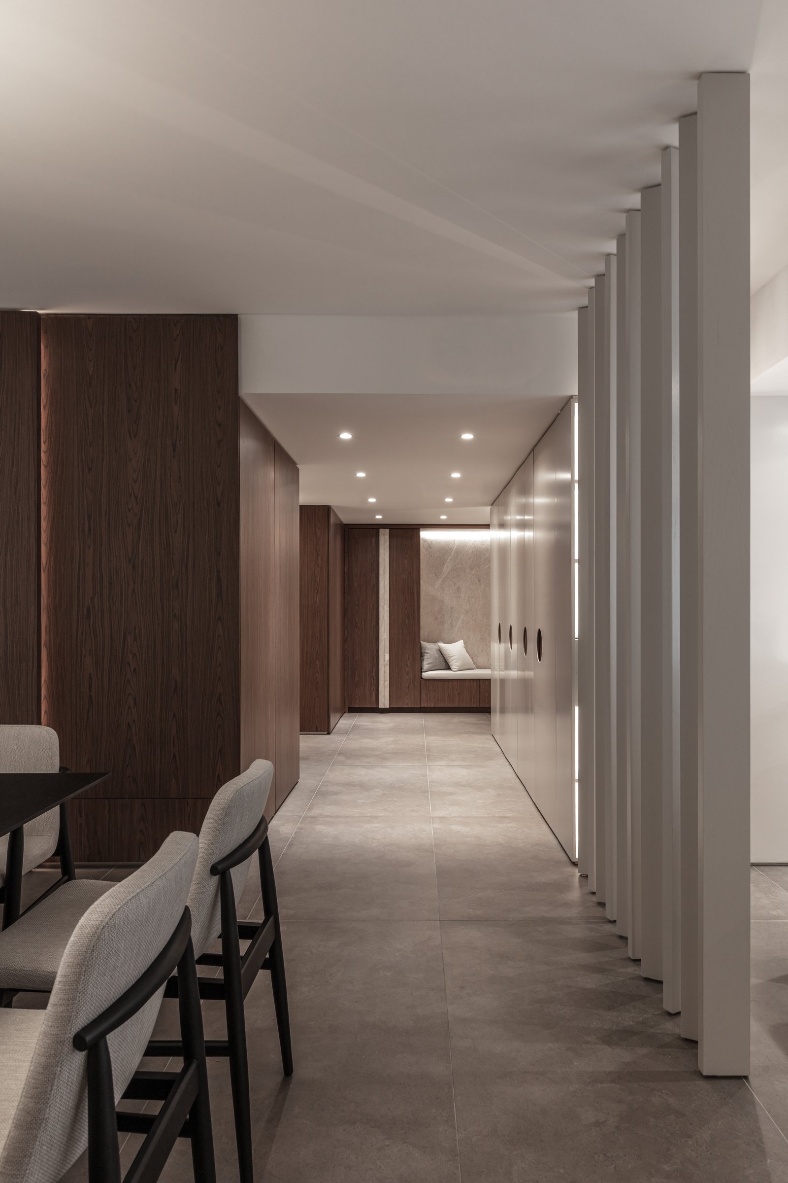 Corredor moderno com painéis de madeira e divisória de ripas verticais — projeto Donna Fiore | Sobrio & sofisticado | Sober & Sophisticated | Lucia Quinteros, por Ren Studio, em Pr
