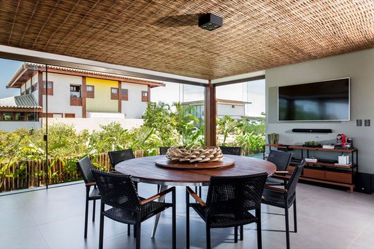 Terraza moderna con comedor circular bajo pergola de madera y vistas — proyecto Residência MQ, por Milcent Arquitetura