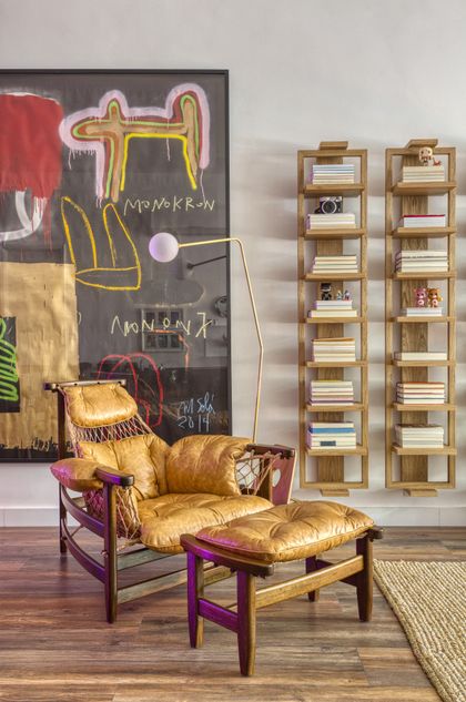 Living con sillón dorado, estantería modular y arte contemporáneo en pared — proyecto Hugo Gloss, por Studio Ro-ca