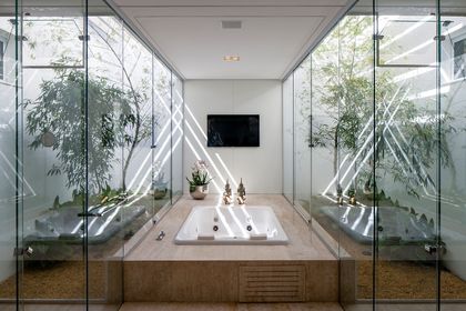 Baño minimalista con bañera integrada y plantas envolventes — proyecto Casa TB, por Aguirre Arquitetura