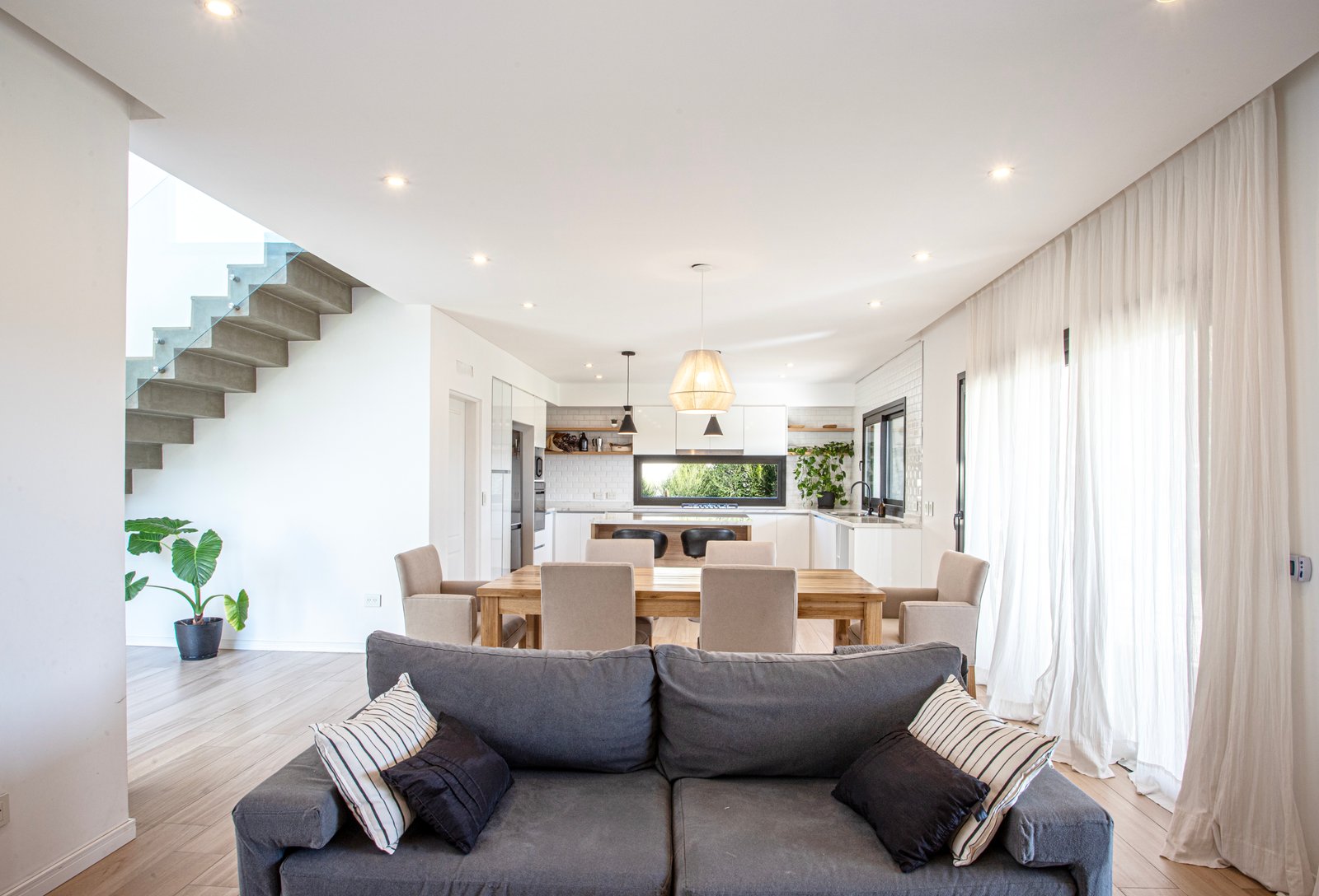 Living comedor y cocina moderna y luminosa con suelo de madera — proyecto SS45, por EZ architects, en Pilar