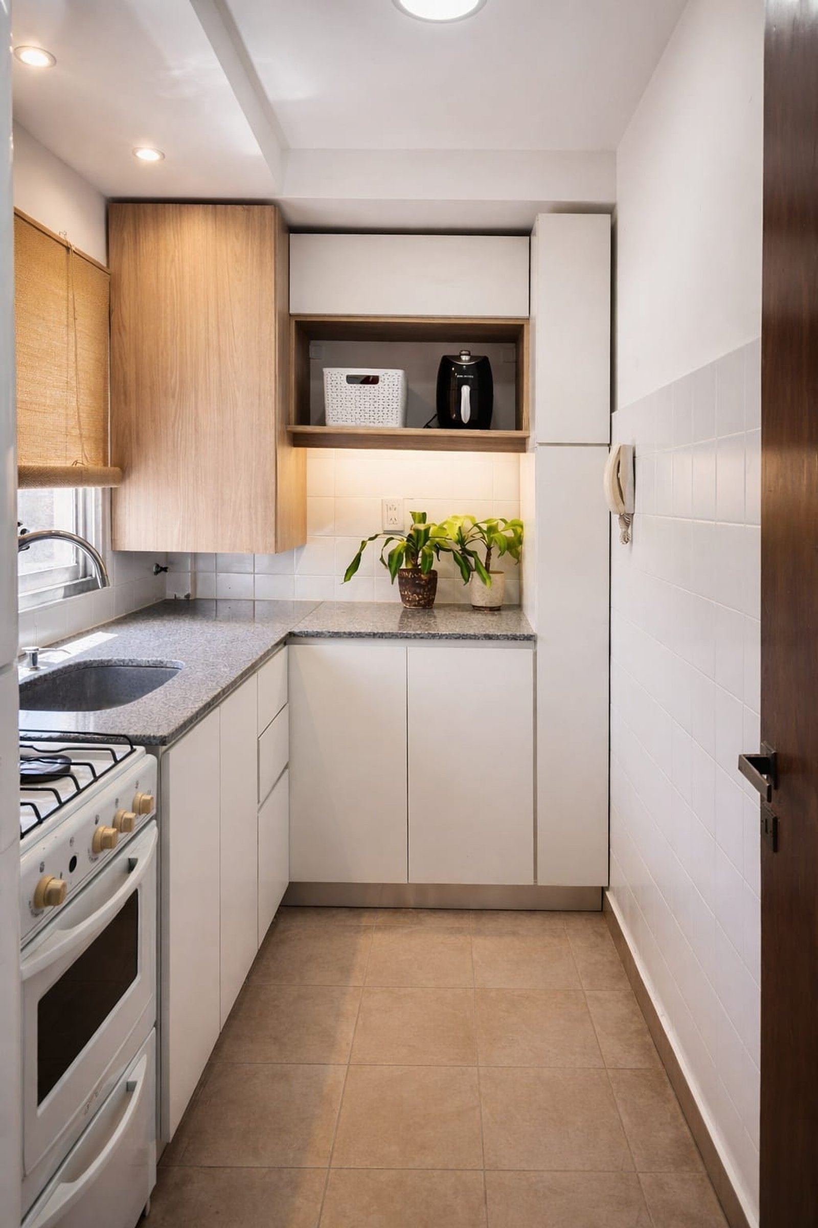 Cocina moderna compacta con muebles de madera y encimera de granito — proyecto Depto. España , por uniKKo Estudio de Diseño, en Mar del Plata