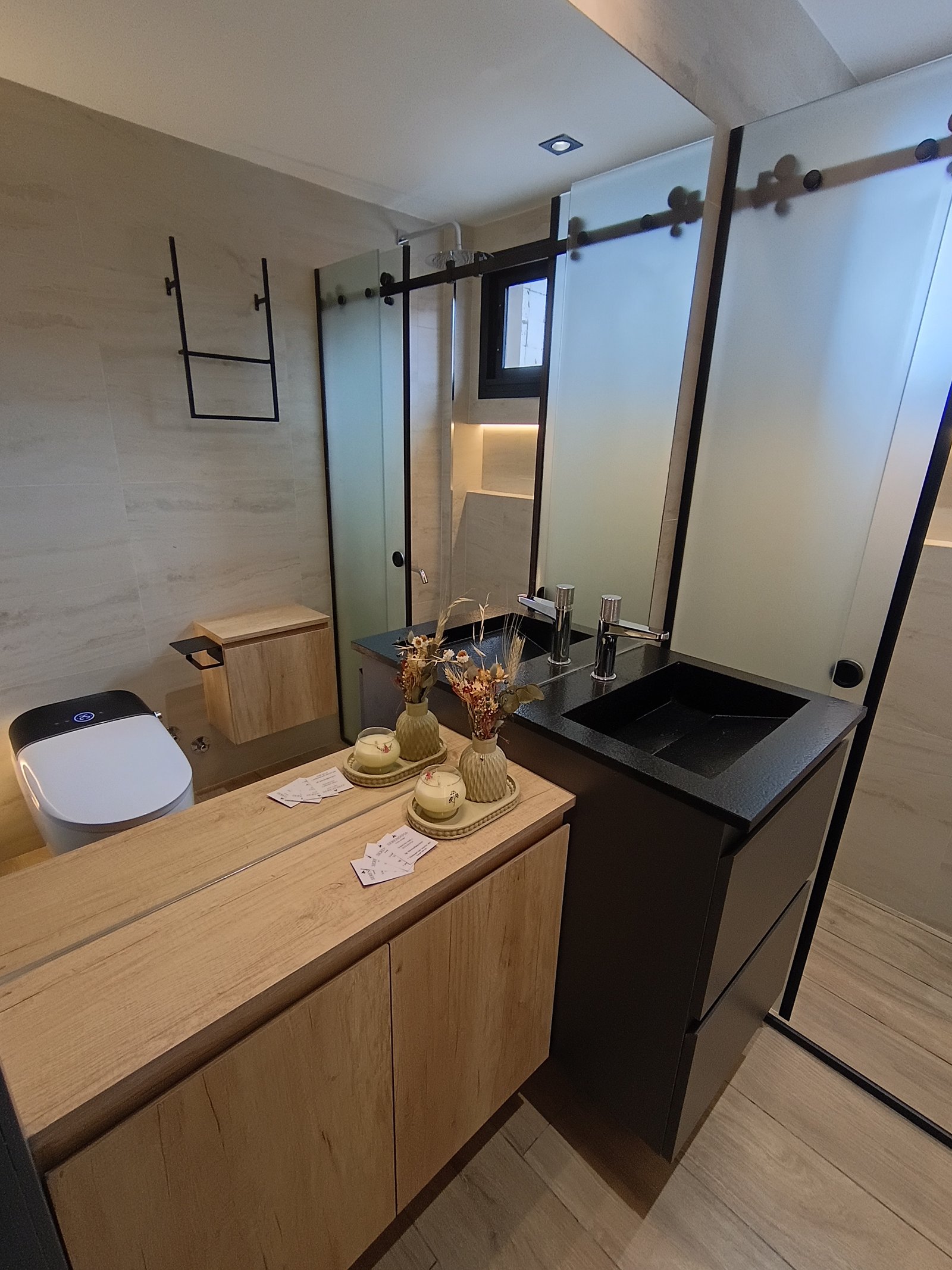 Baño moderno con vanitory de madera, lavabo negro y ducha de vidrio — proyecto Obra pelle, por vetainteriores, en Av. Carlos Pellegrini 1400