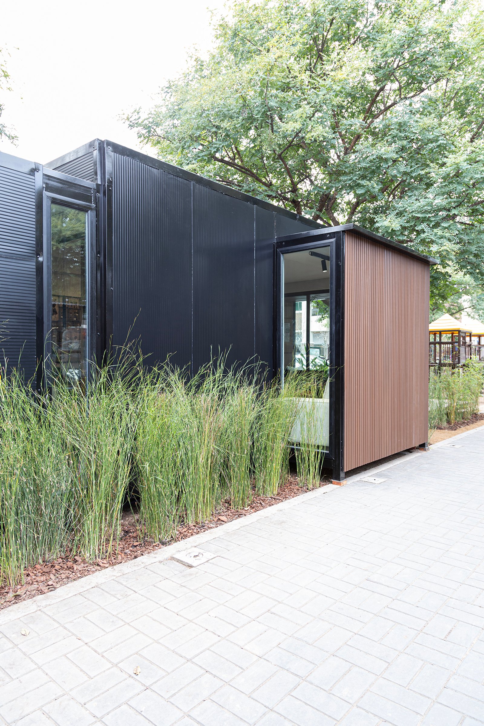 fachada moderna con césped ornamental y detalles de madera — proyecto Interiorismo Tiny House , por LINEA NETA diseño interior , en B1648 Tigre