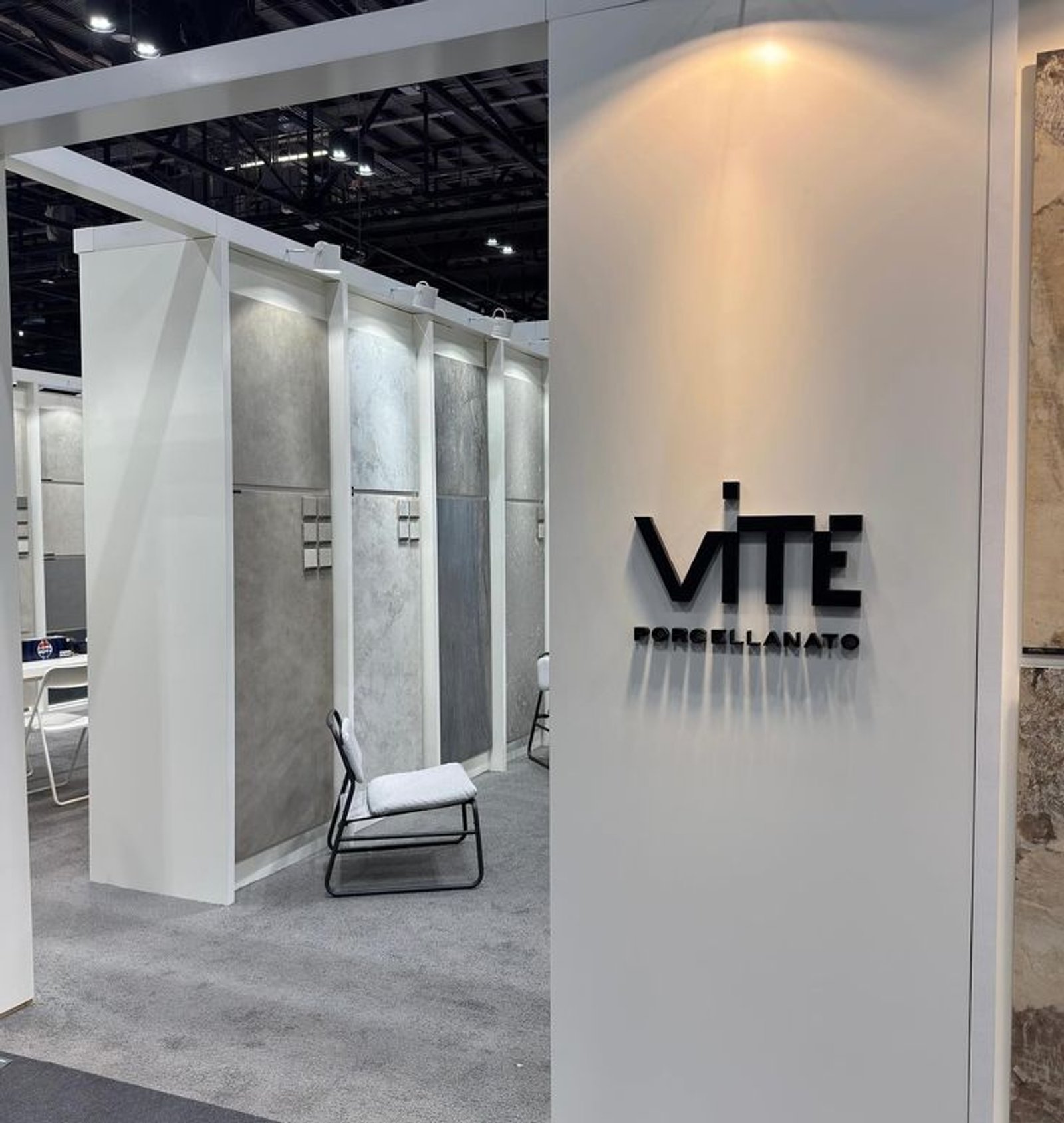 Espacio comercial moderno con paneles de concreto y logo destacado — proyecto Coverings 2025, por Vite Porcellanato, en Orlando