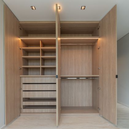 Amplio vestidor de madera clara con iluminación integrada — proyecto Yacht - Estudio CCWay, por ABEJA CONCEPT, en Av. de la Ribera 560