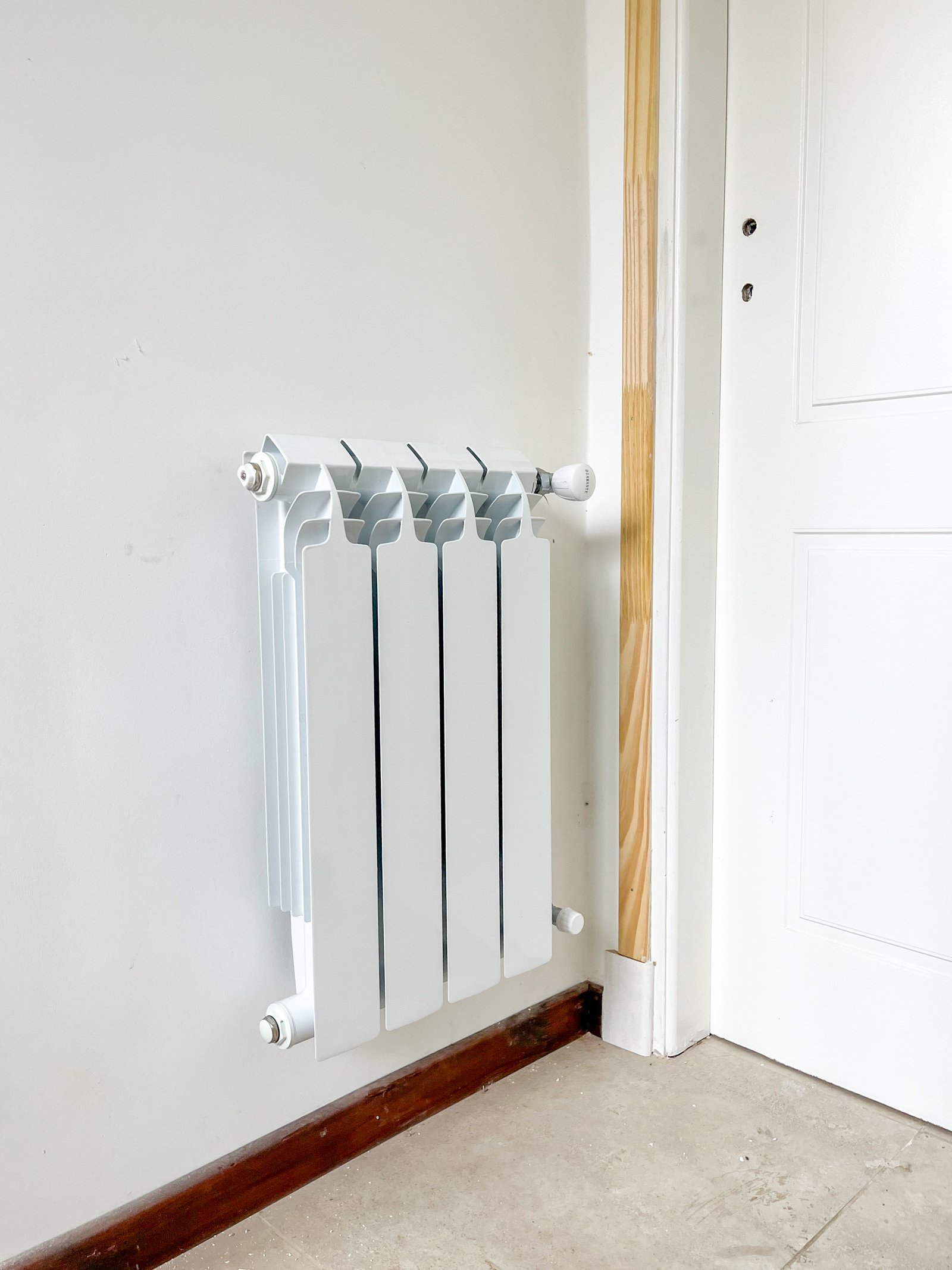 radiador blanco en pared blanca con suelo de cerámica — proyecto Instalación de Radiadores en Tigre, por Climatizacion HD, en B1648 Tigre