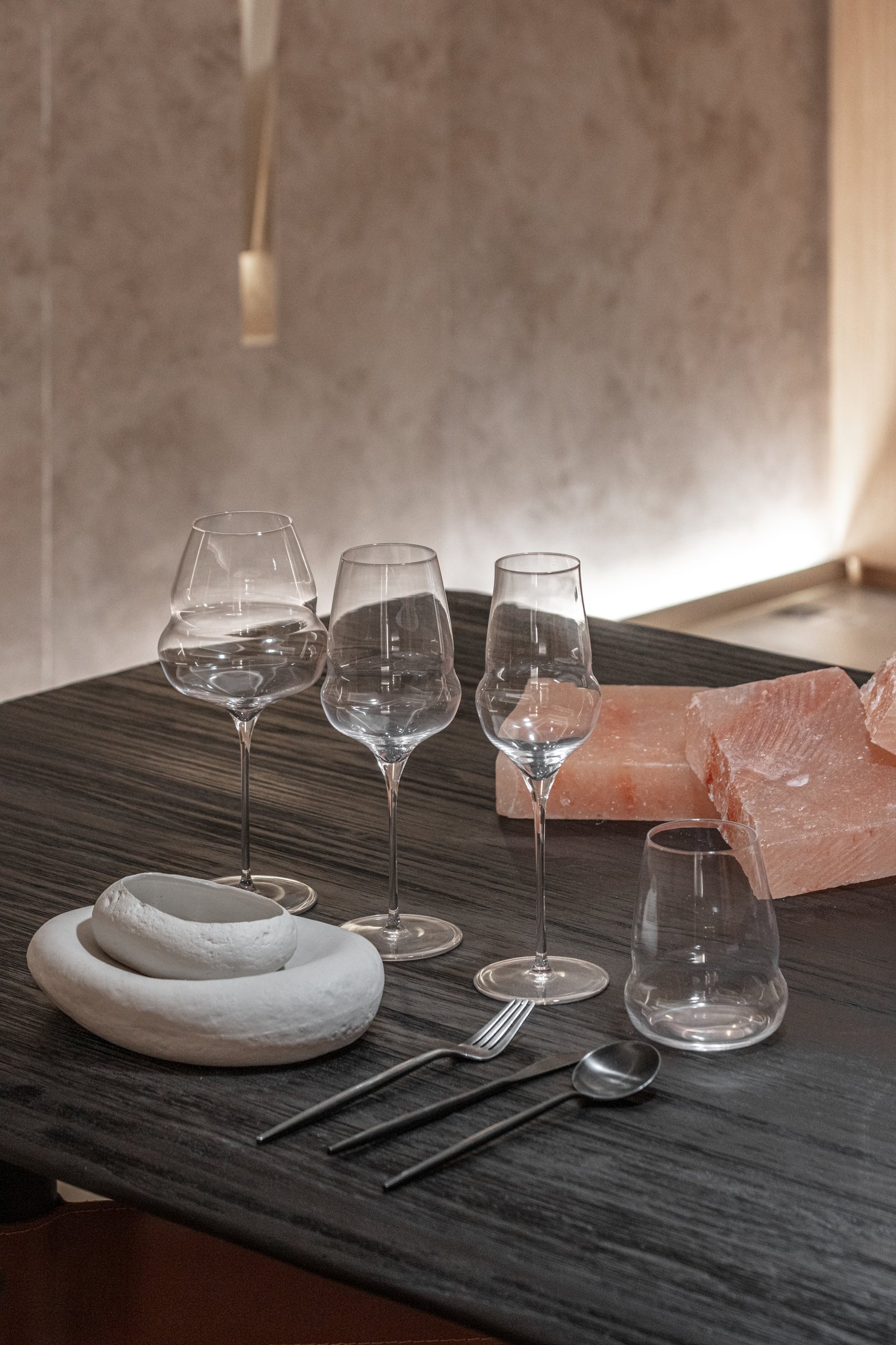 Mesa de comedor moderna con copas únicas y bloques de sal rosa — proyecto Casa Foa 2025 | Degustando experiencias | Tasting experiences | Lucia Quinteros, por Ren Studio, en Cdad. 