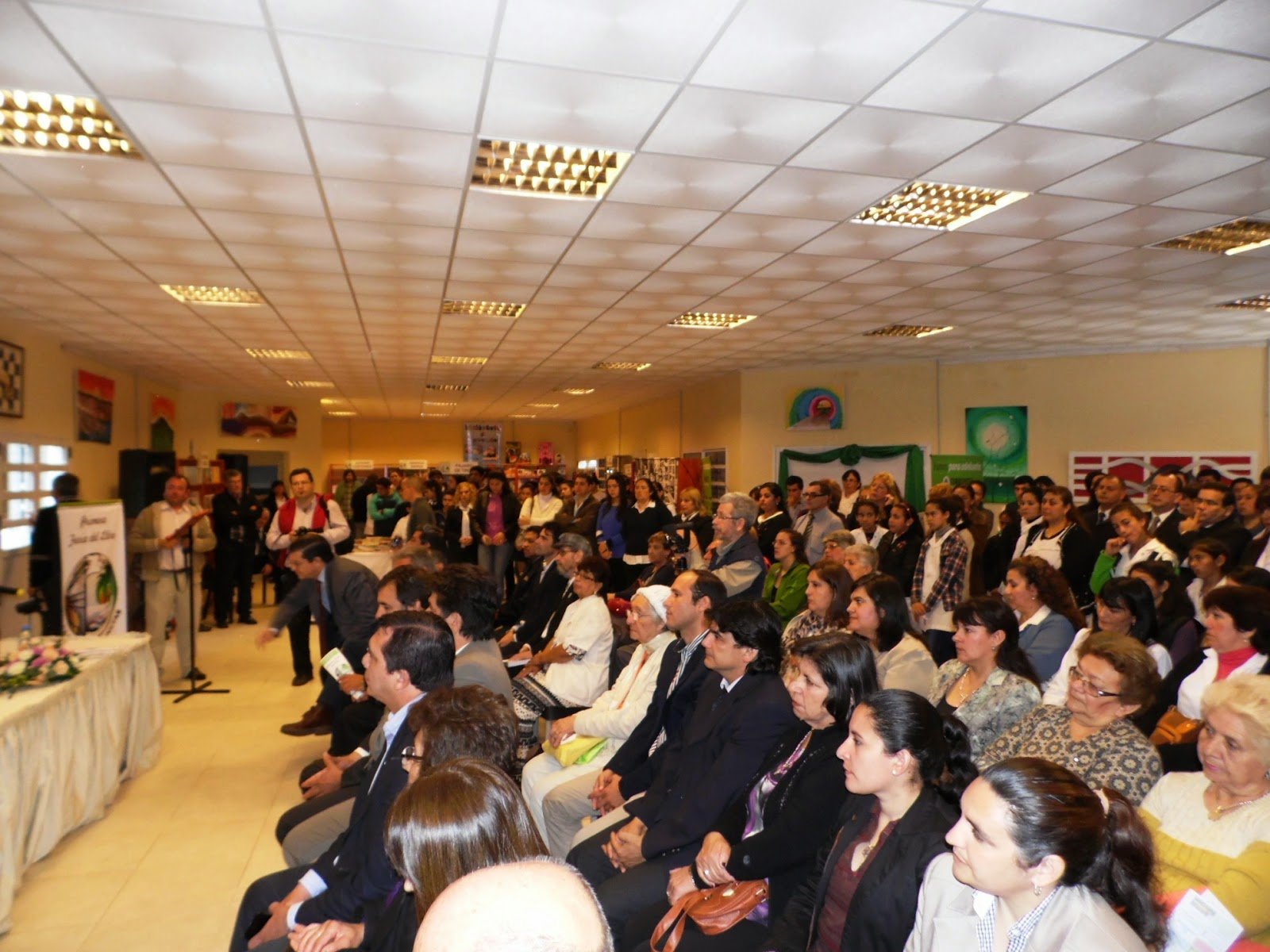 asamblea de personas en sala con paneles de madera y techo claro — proyecto Biblioteca Publica, Dr. Juan Manuel Rivera. Caa Cati, Corrientes., por Arquitecto Gustavo Maidana, en Ca