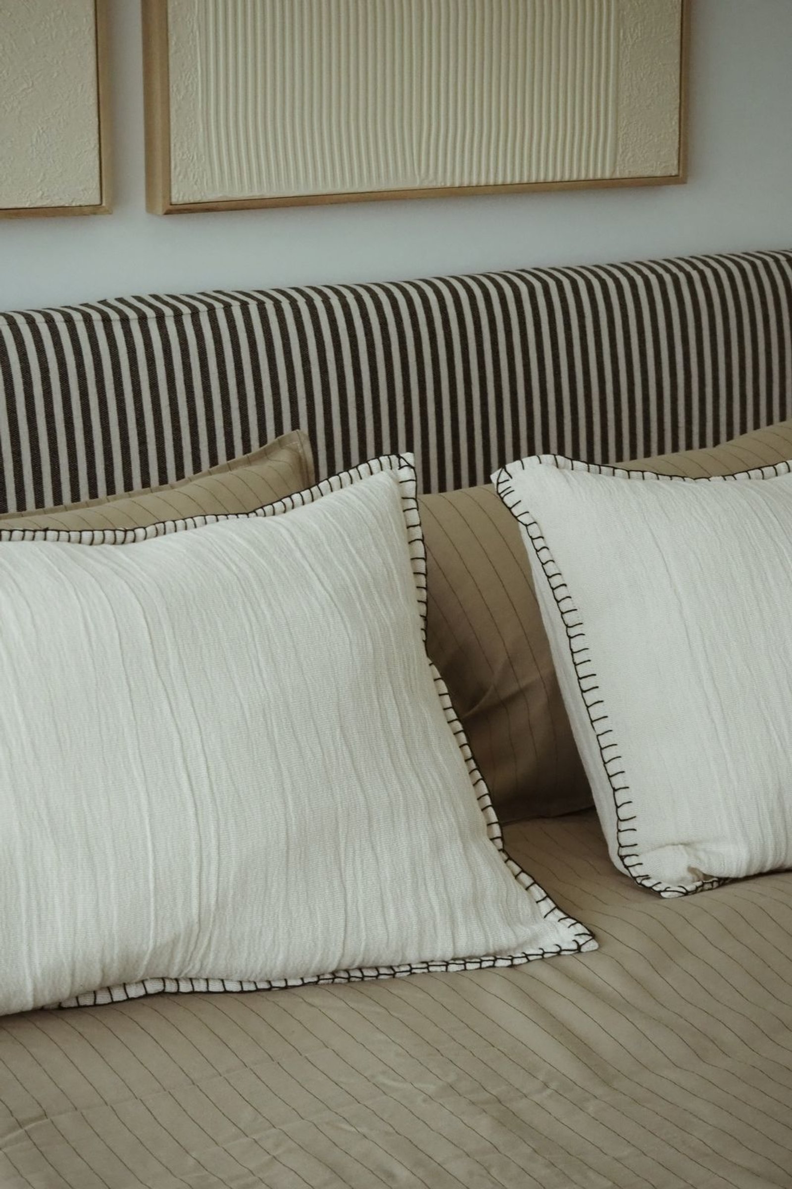 Quarto com almofadas brancas plissadas e costura preta — projeto RIO, por APATHEIA, em Provincia de Buenos Aires