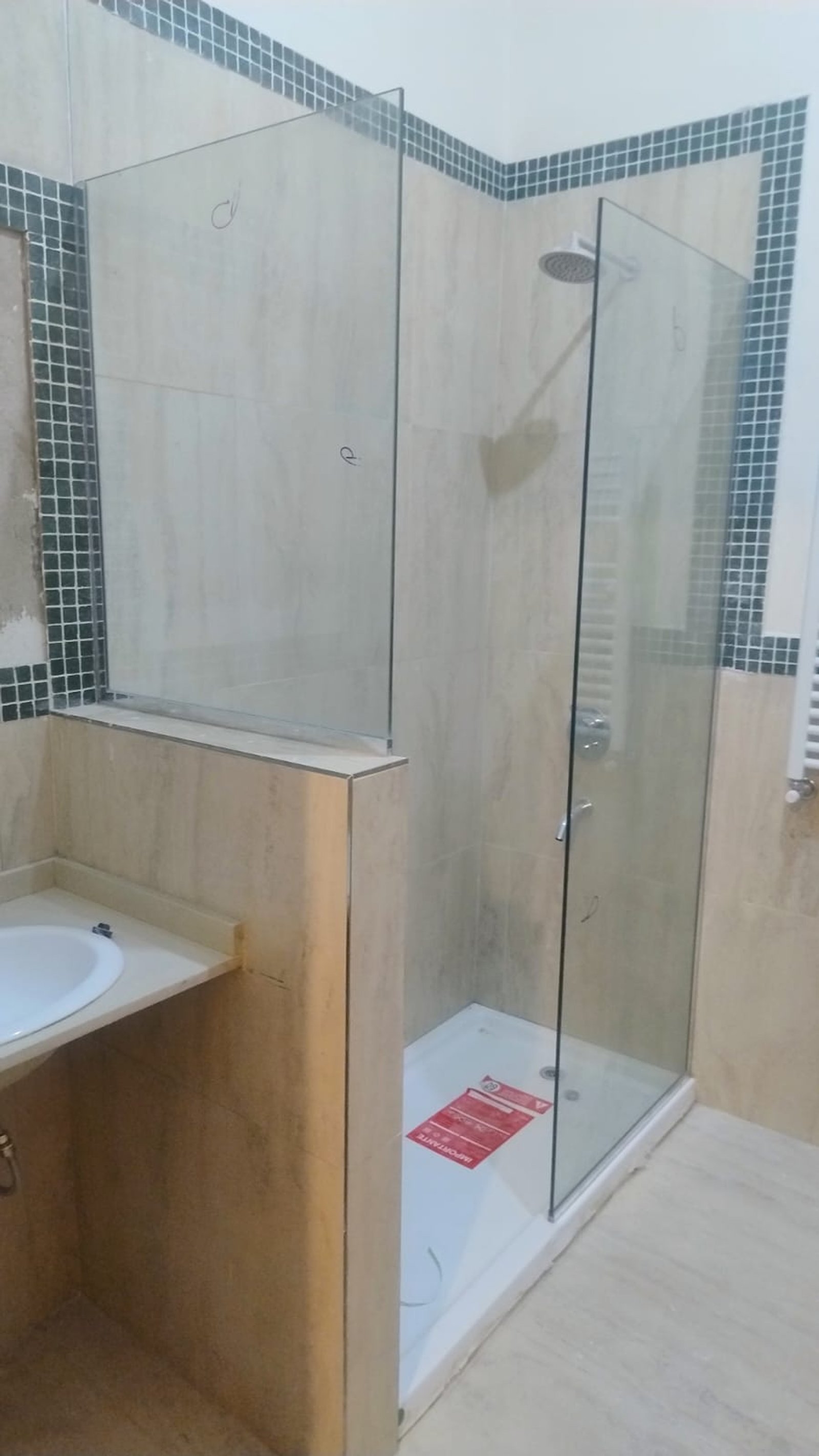 baño moderno con ducha de vidrio y paredes de piedra — proyecto Mamparas paño fijo u aluminio platil, por Cristalcenter, en Balvanera