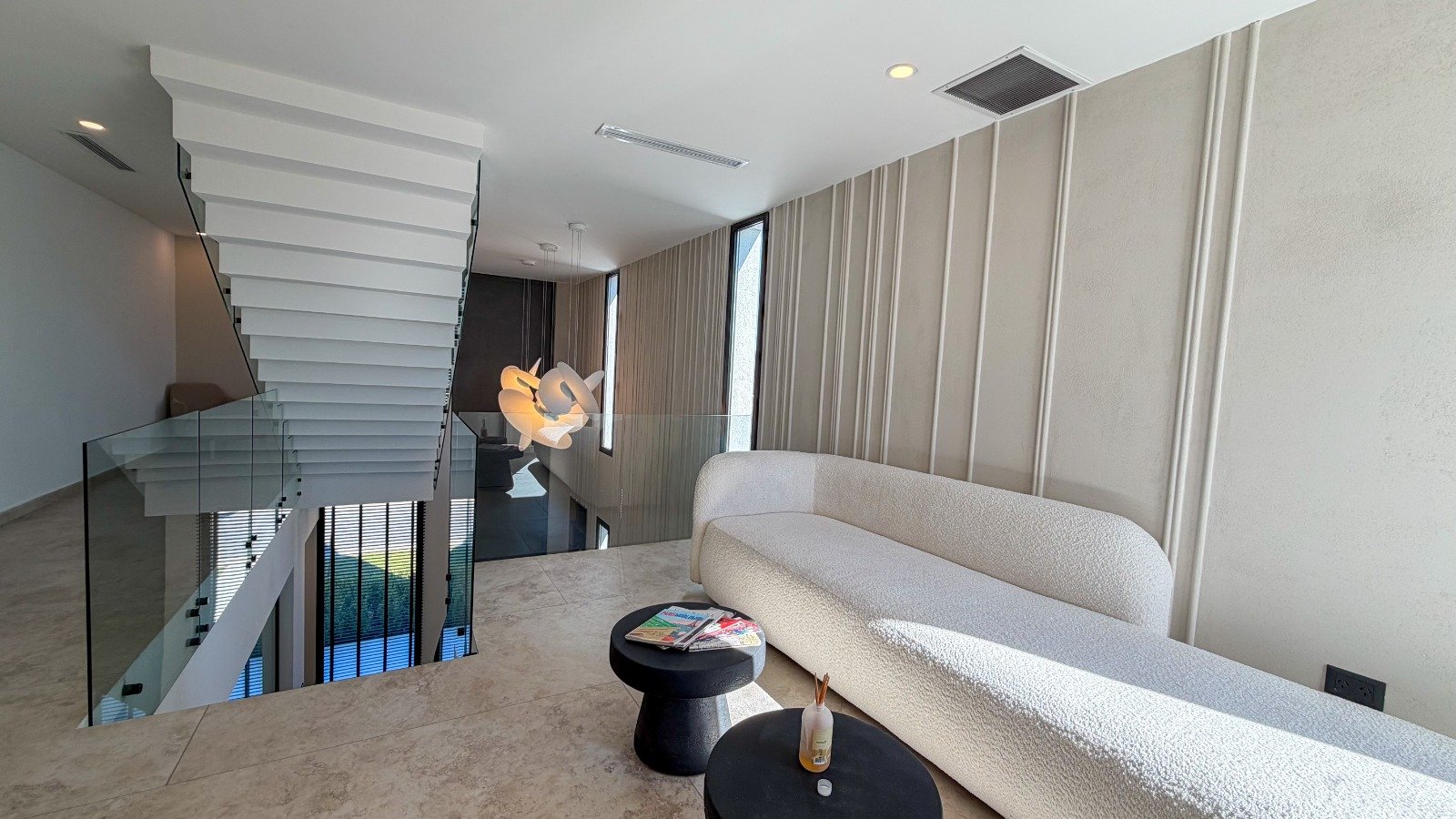 Living moderno con sofá curvo blanco y escalera flotante — proyecto Yatch 278, por CIFARELLI arquitectos, en Tigre