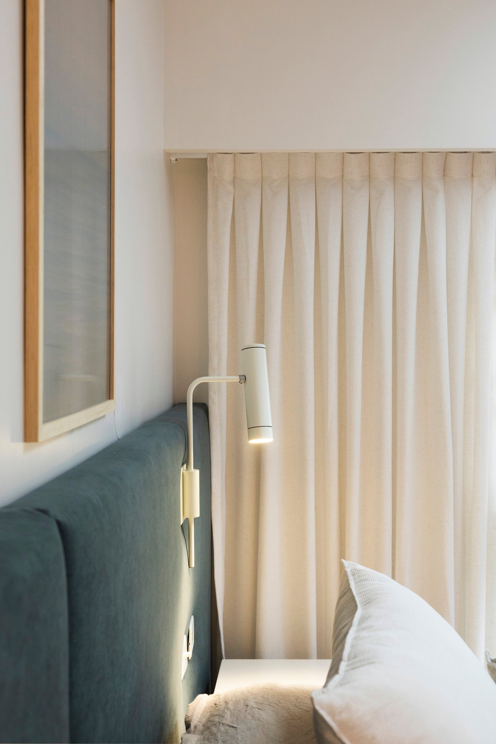 Dormitorio moderno con luz de pared y cabecero tapizado verde — proyecto MONASTERIO, por La Nave Arq., en Vicente López