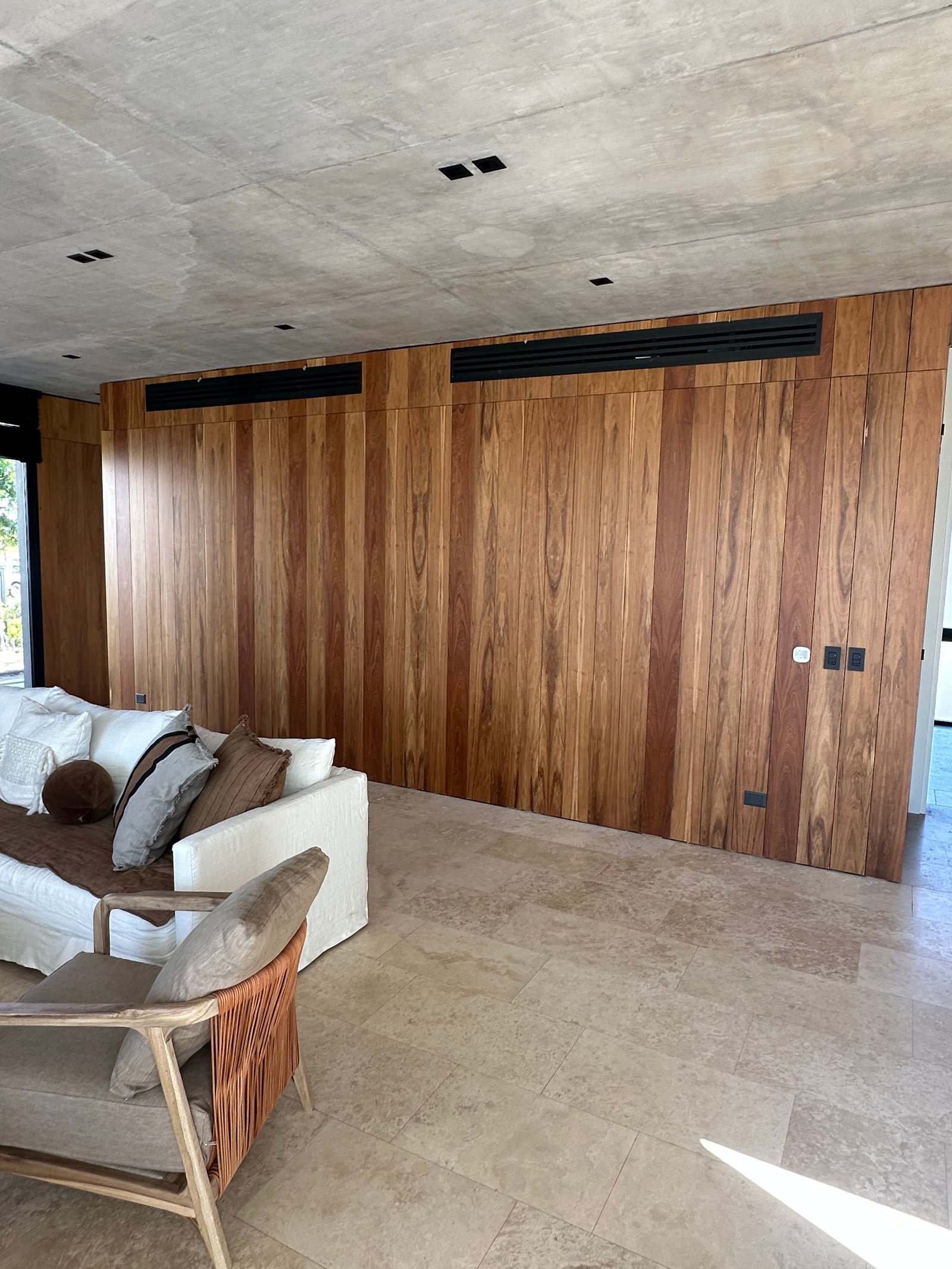 Sala moderna con paredes de madera y techo de hormigón — proyecto La Calesa - Estudio Leone, por ABEJA CONCEPT, en Pilar
