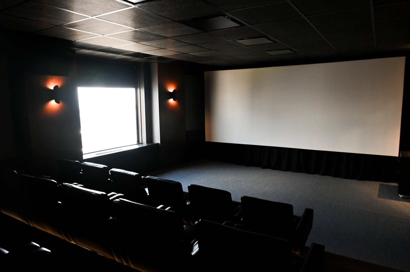 sala de cinema vazia com tela grande e assentos escuros — projeto Oficinas UIP, por cromo., em Retiro