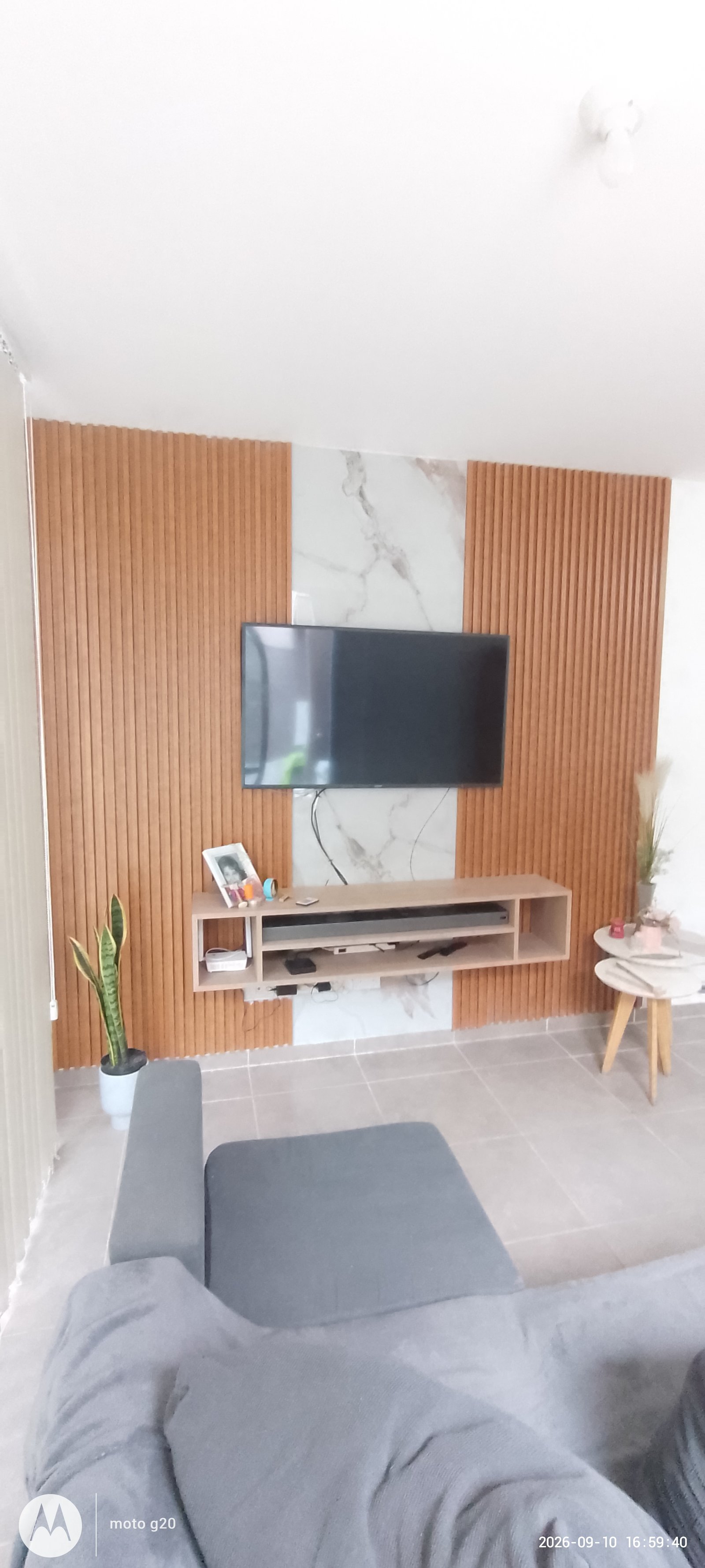 Sala com parede de madeira e mármore, TV flutuante e sofá cinza — projeto Cocina minimalista, por Abrego Amoblamientos, em Urquiza
