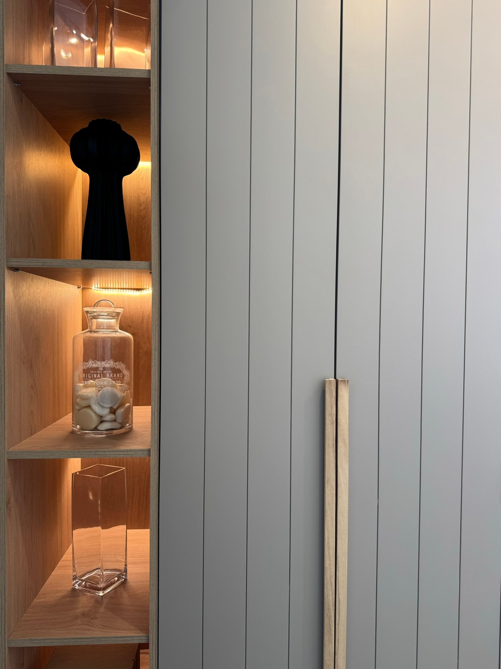 Prateleiras embutidas de madeira com iluminação quente e objetos decorativos — projeto Matienzo, por MDBK Arquitectura, em Belgrano